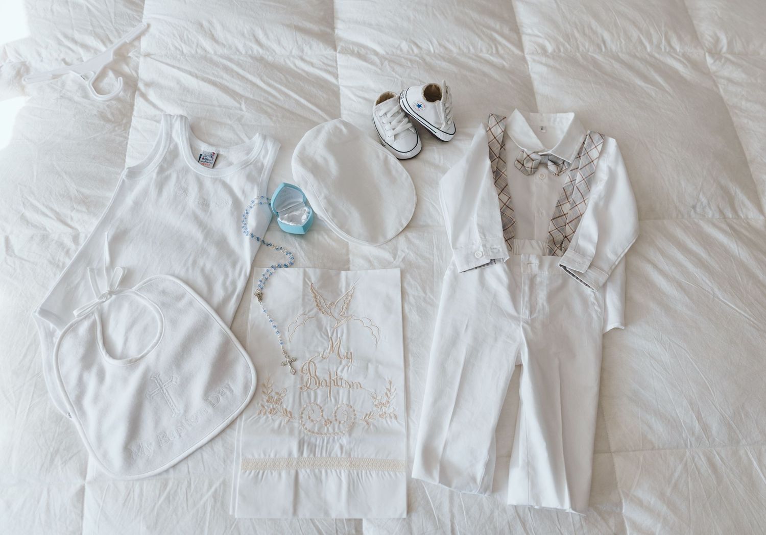 Collection of white wedding accessories arranged on light background.