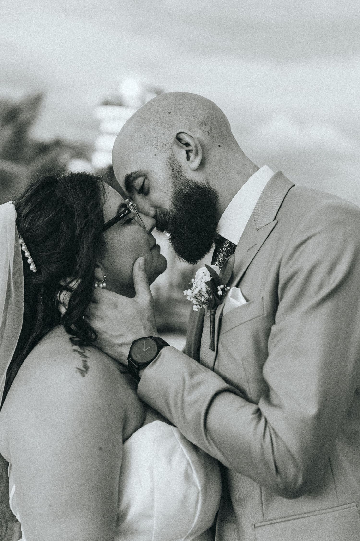 Black and white intimate wedding portrait capturing a tender moment between newlyweds.