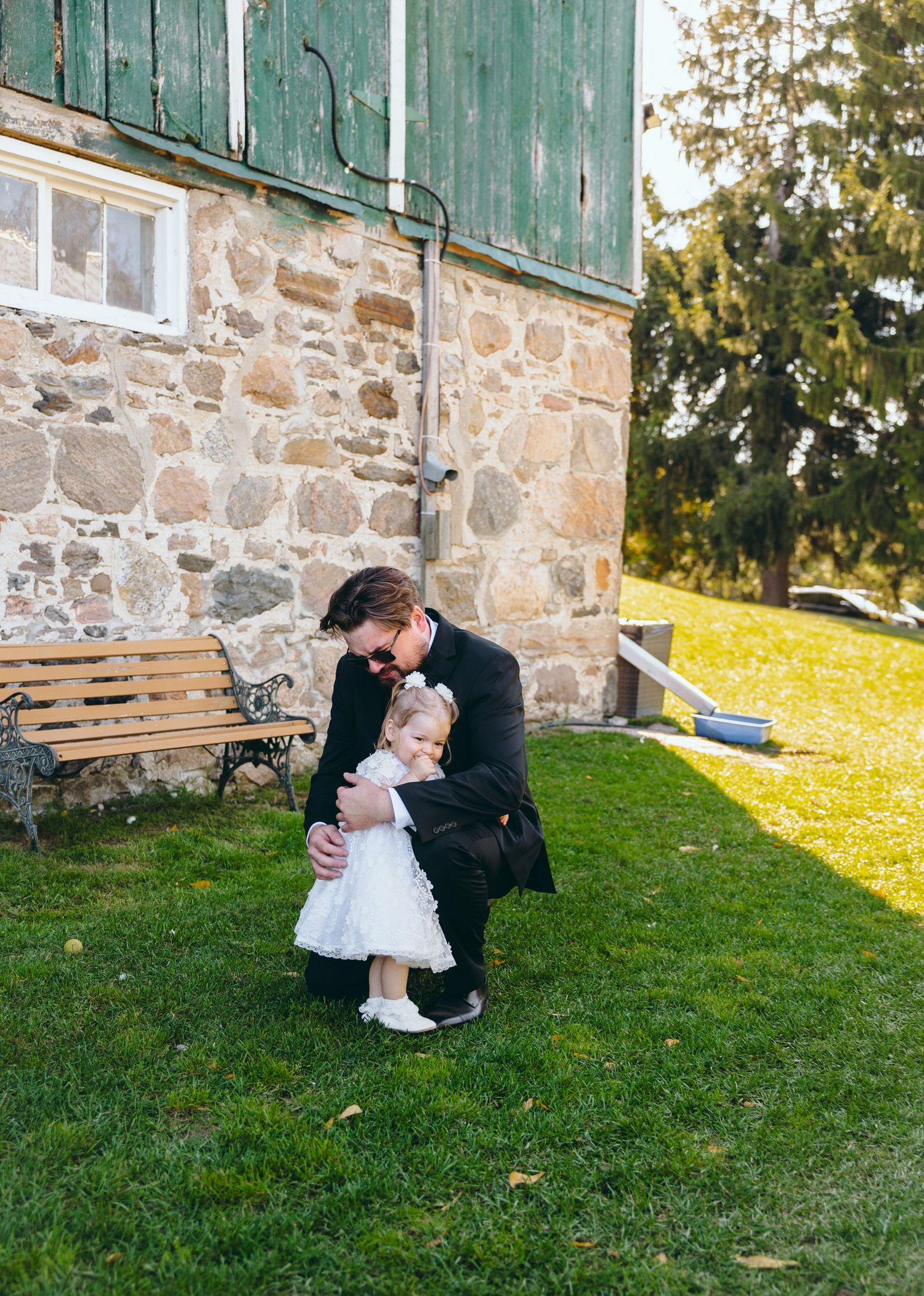 Stone building with green doors provides backdrop for outdoor photography session.