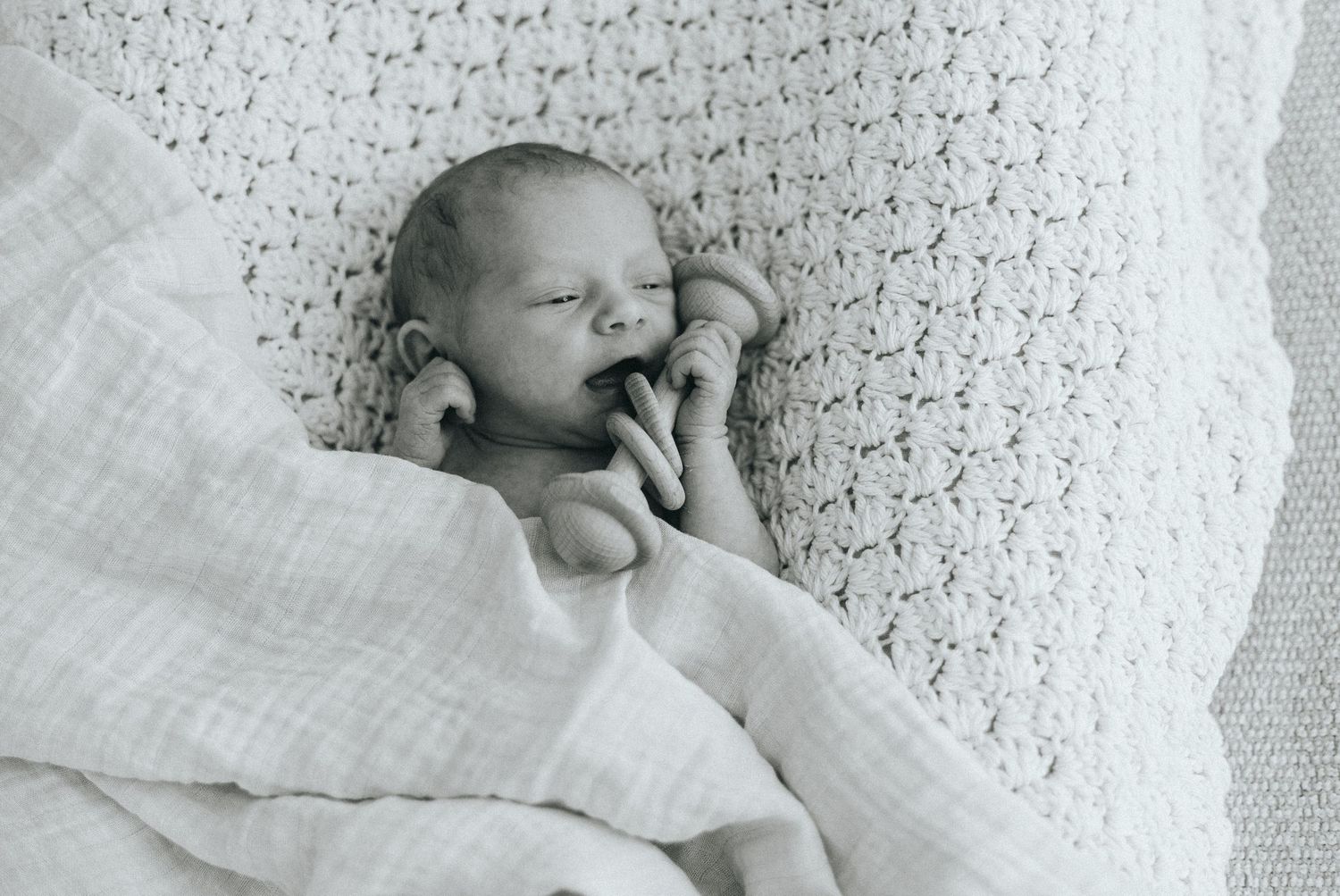 Series of black and white photos showing a newborn baby on textured fabric.