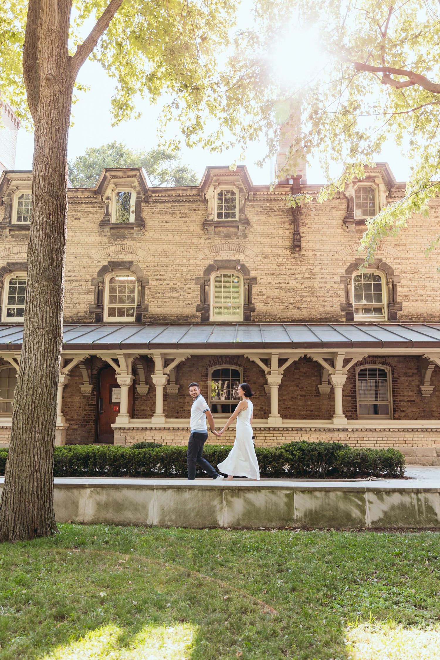 Gothic architecture of historic church building with sunlight filtering through trees.