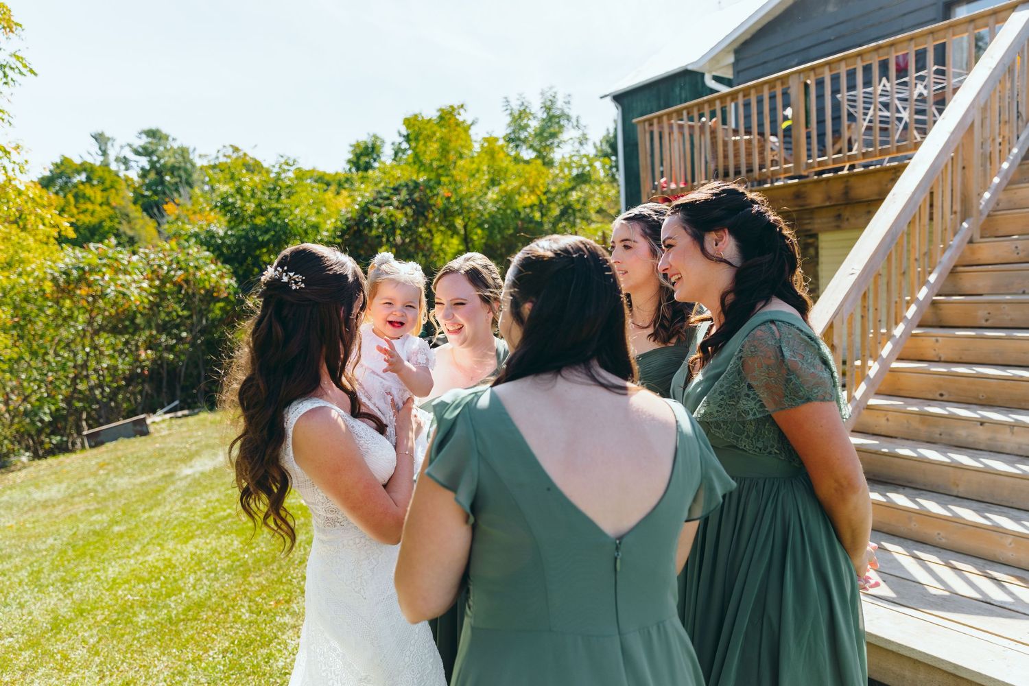 Wedding party enjoying celebratory drinks together on a sunny outdoor patio.