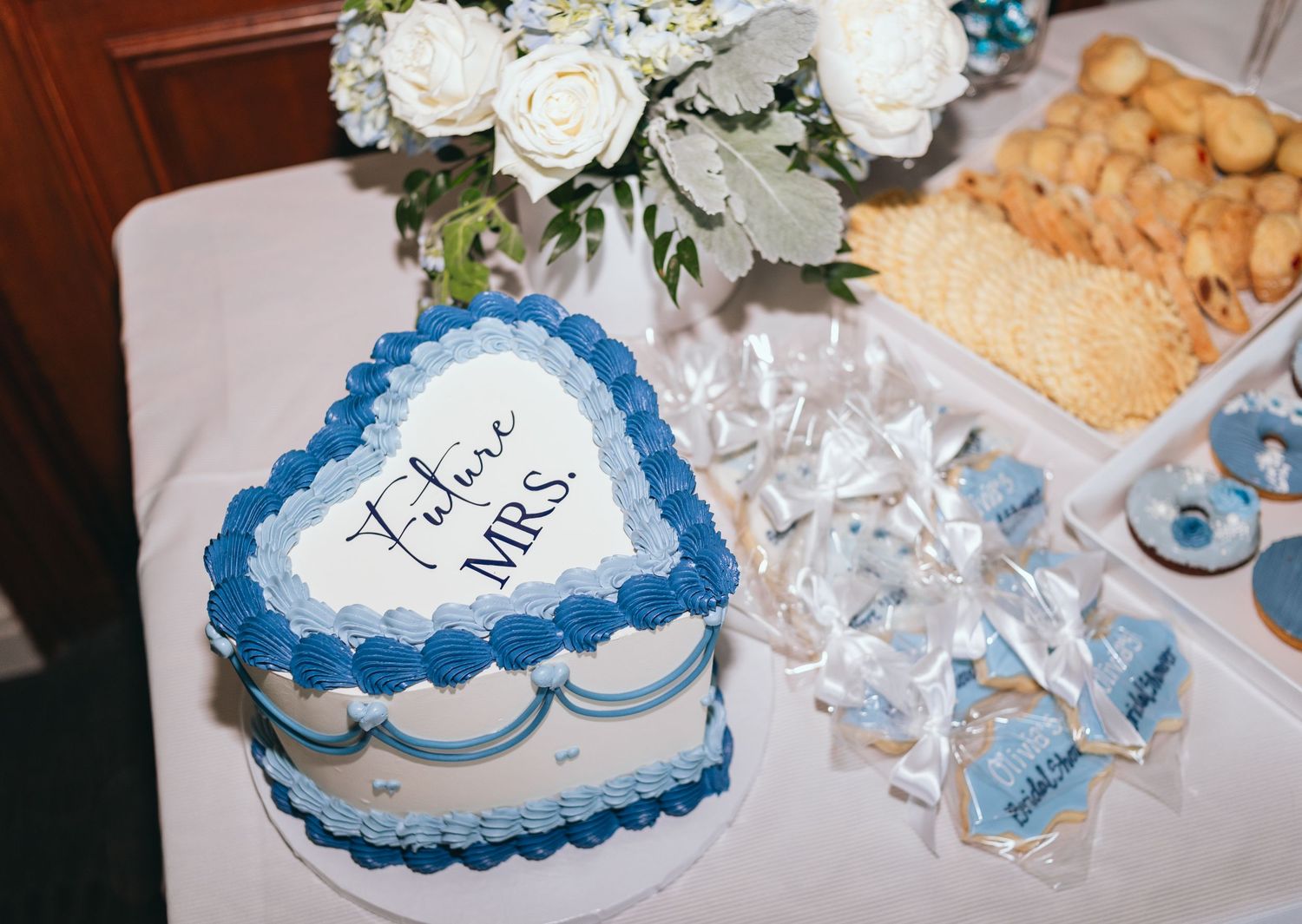 Wedding reception table with blue and white decorative elements and snacks.