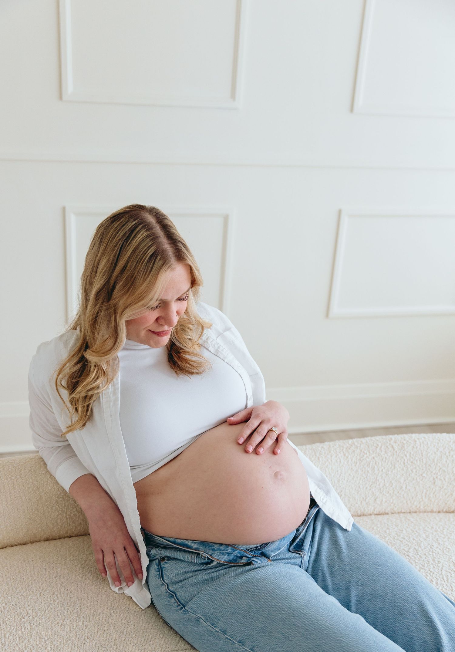 Casual maternity photos showing pregnant woman in jeans and white top.