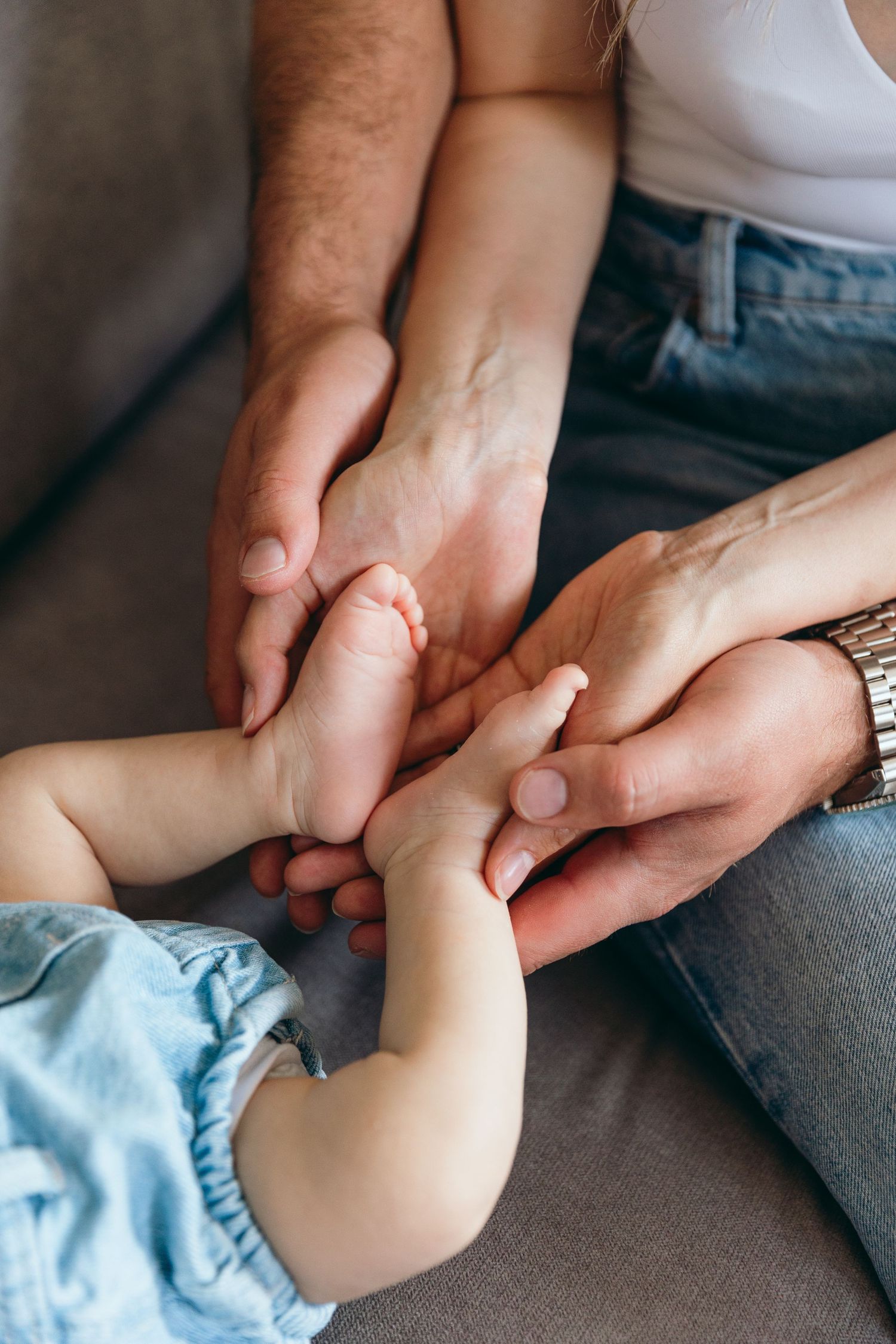 Close-up of hands gently massaging a baby's foot in a nurturing gesture.