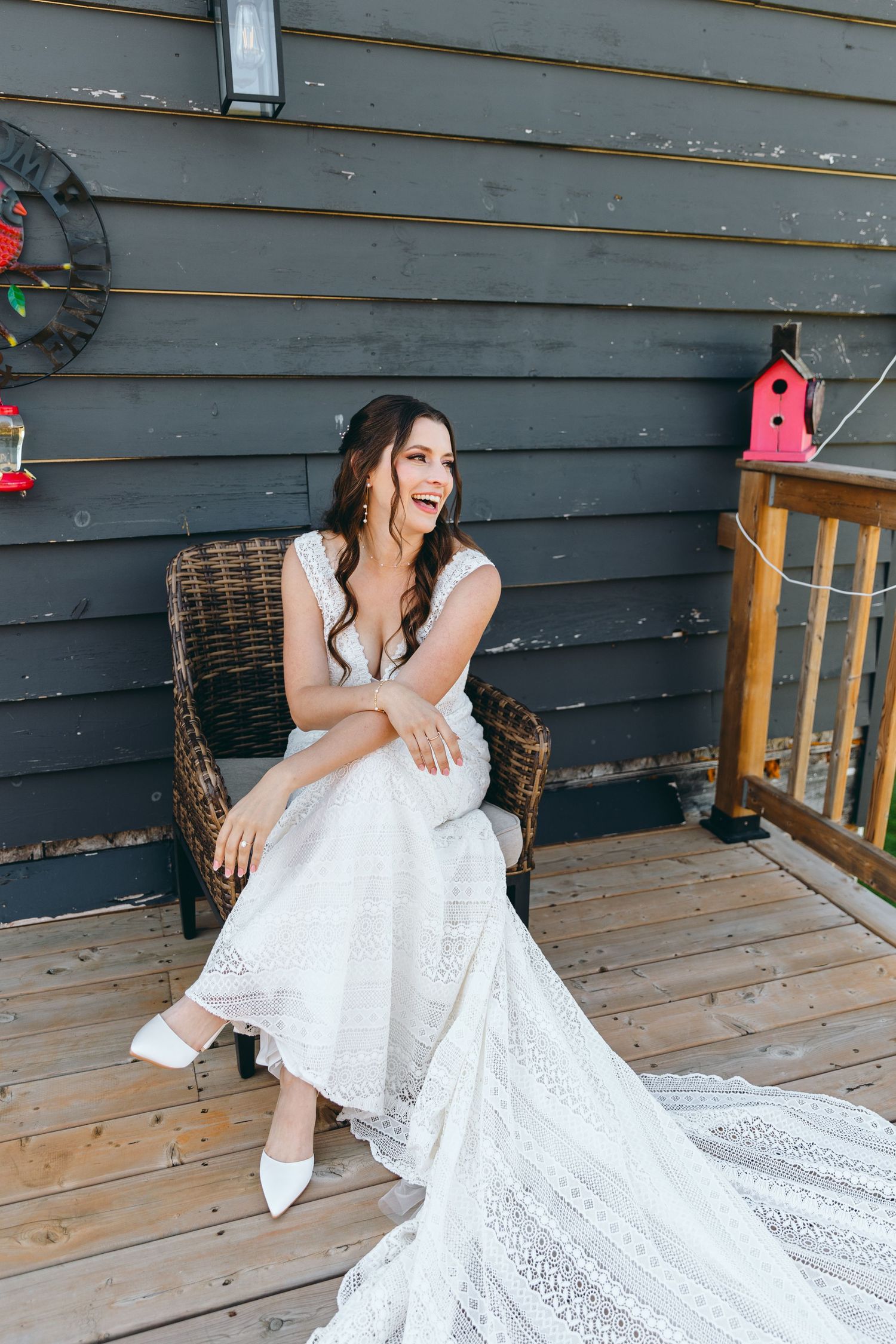 Elegant white bridal gown with intricate lace details photographed on a rustic porch.