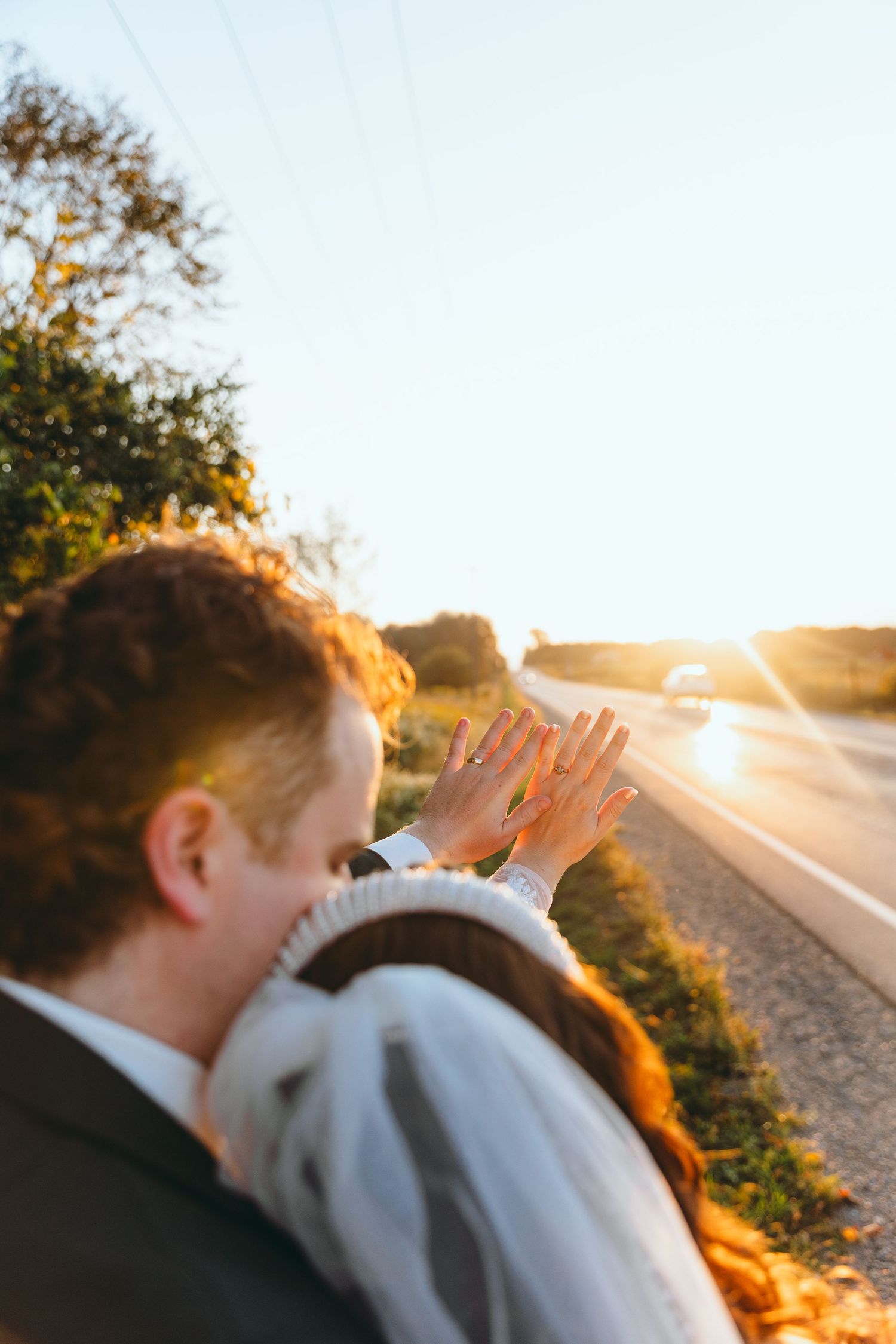 Romantic sunset silhouette of couple sharing intimate moment on country road.