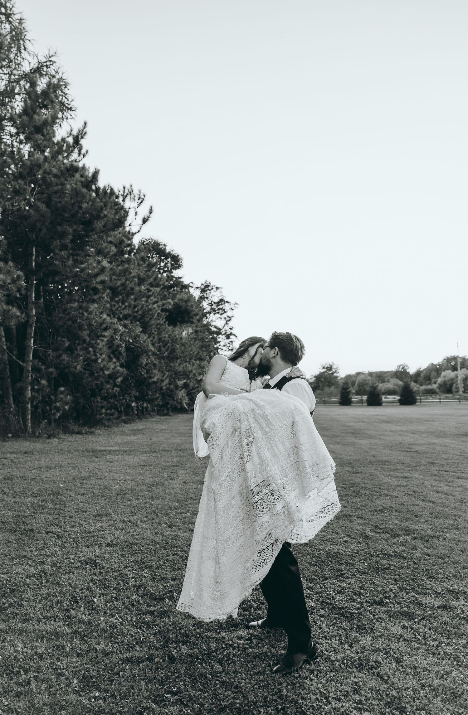 Black and white wedding photos showing romantic dance poses in an open field.