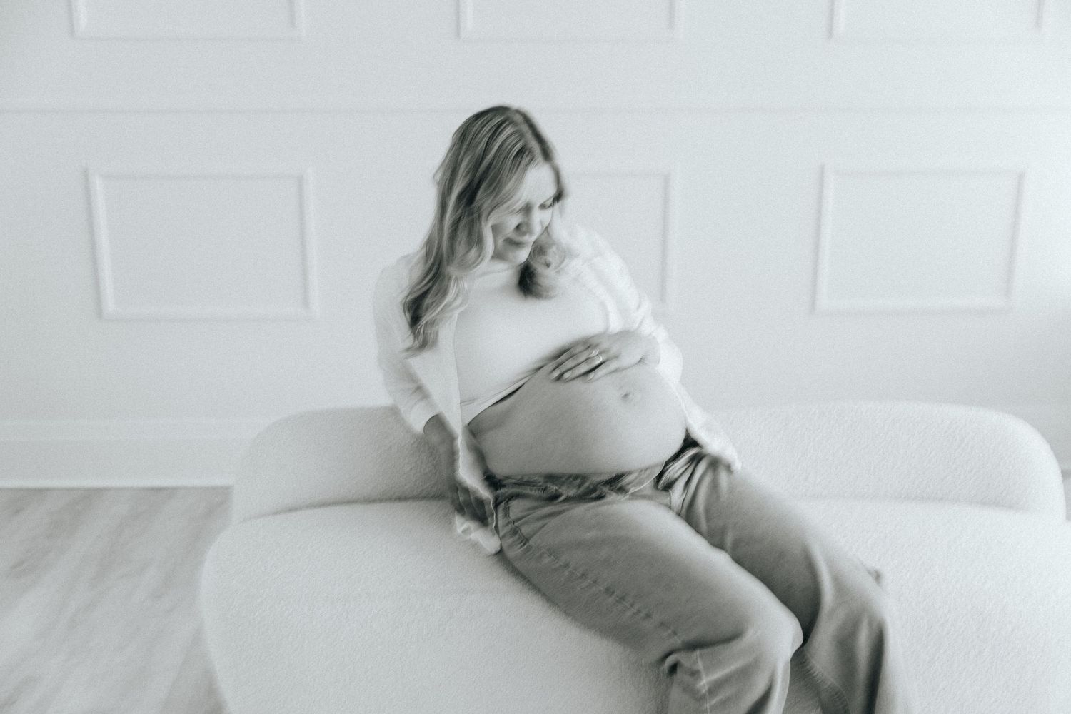 Minimalist maternity scene with white walls and natural lighting.
