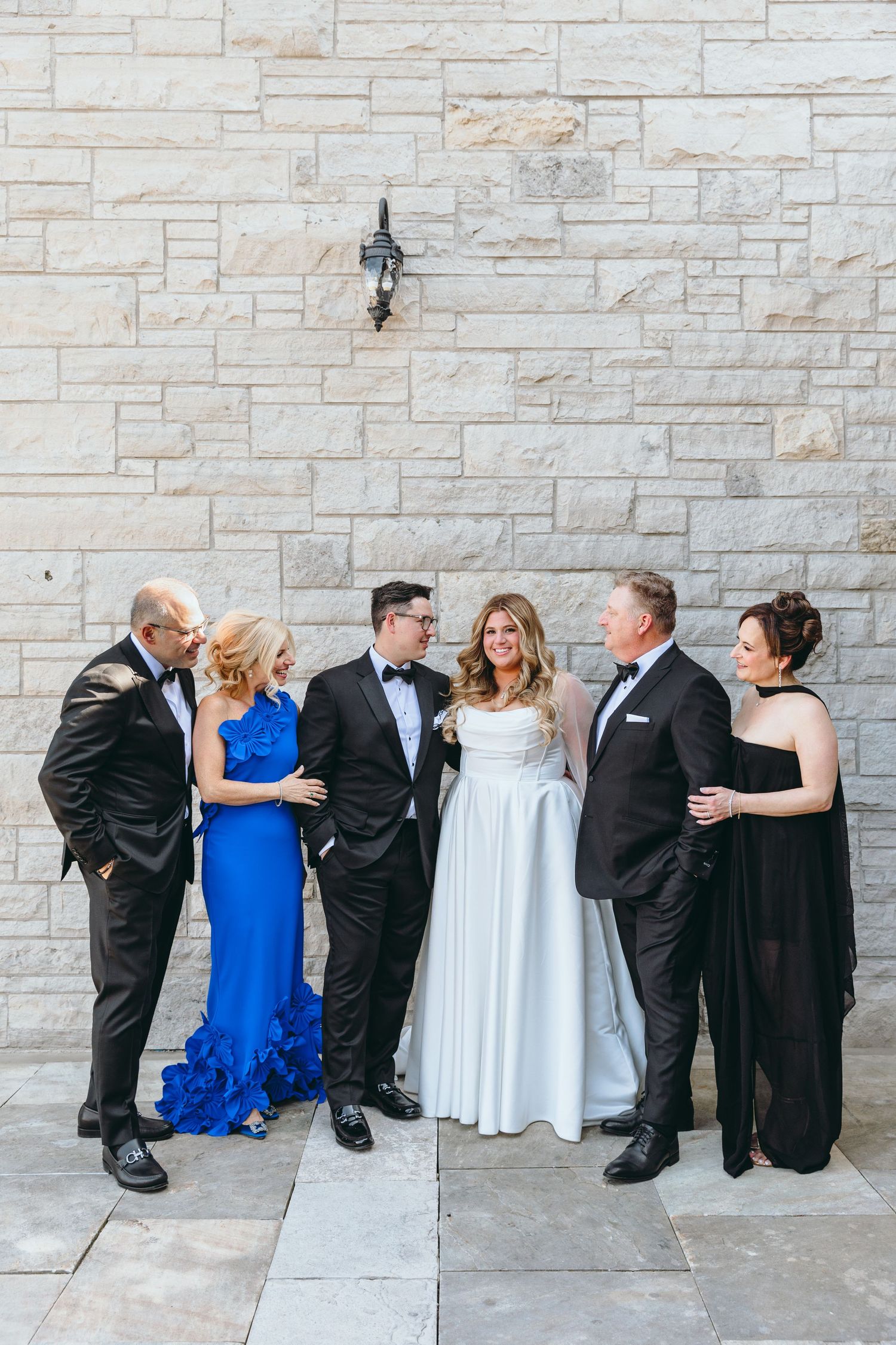 Formal group photo against stone wall.