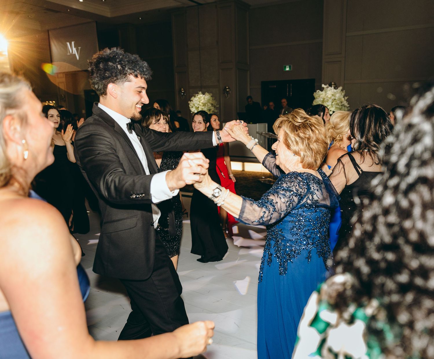 Wedding guests dancing and celebrating at an elegant reception.