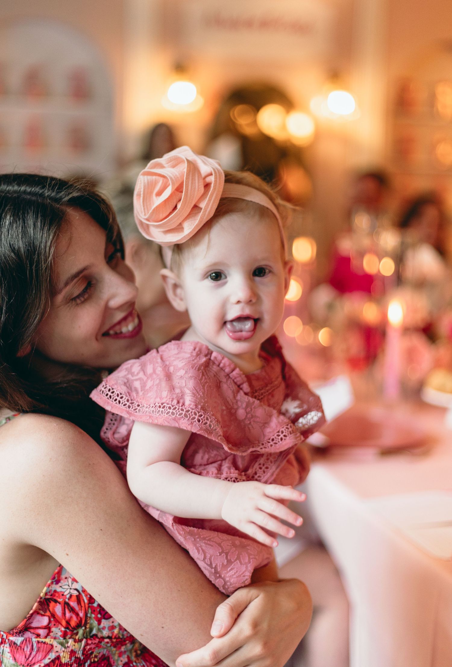 Sweet moments captured at a pink-themed celebration with delicate decorations and warm lighting.