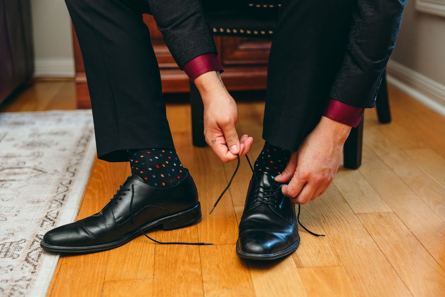 Close-up shots of formal black dress shoes and socks being put on for a wedding ceremony.