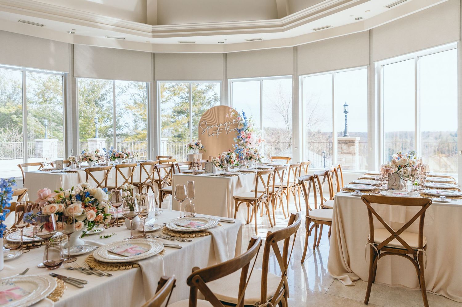 Elegant wedding reception venue with round tables and large windows overlooking scenic views.