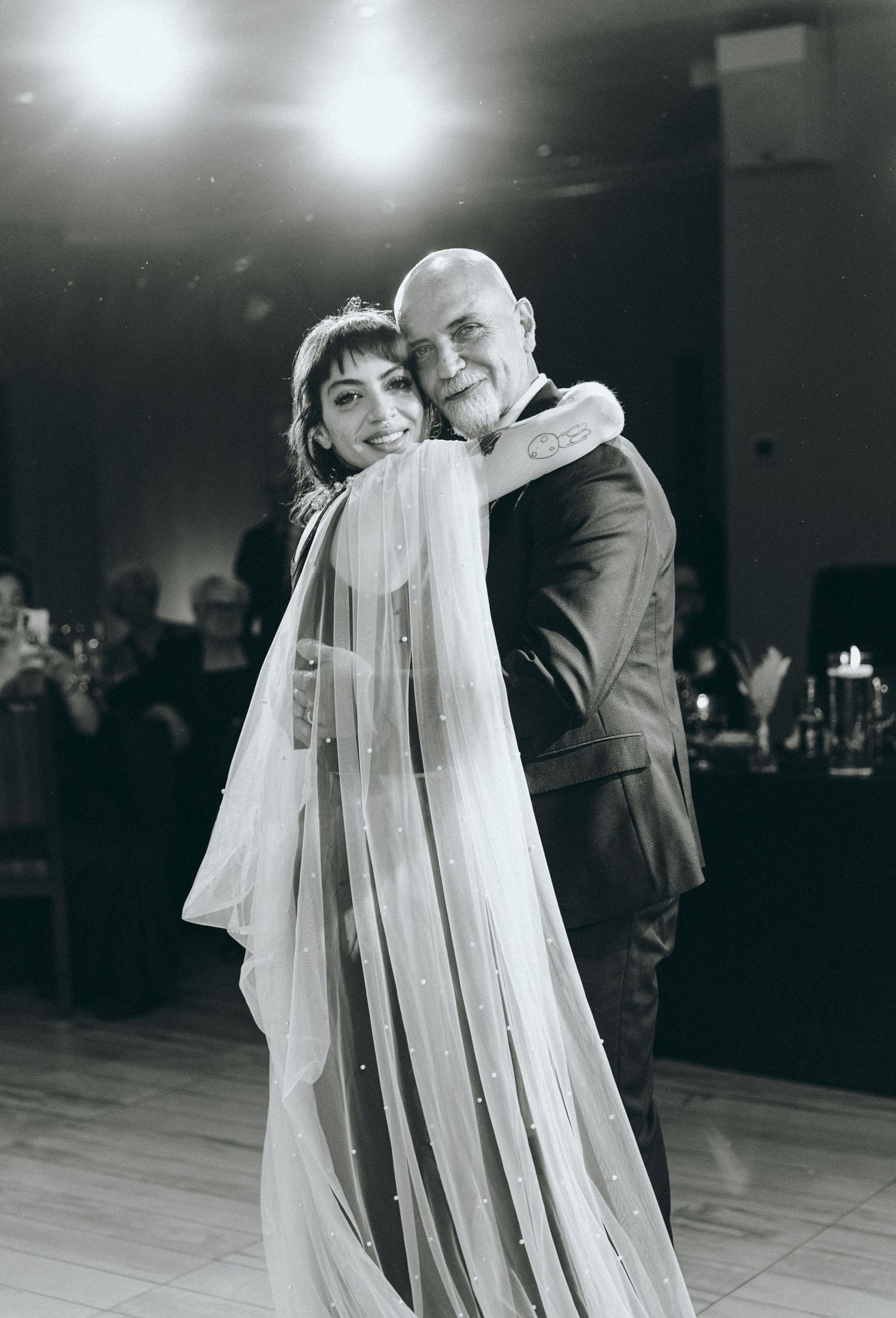 A romantic first dance sequence at a wedding reception with the bride's veil flowing elegantly.