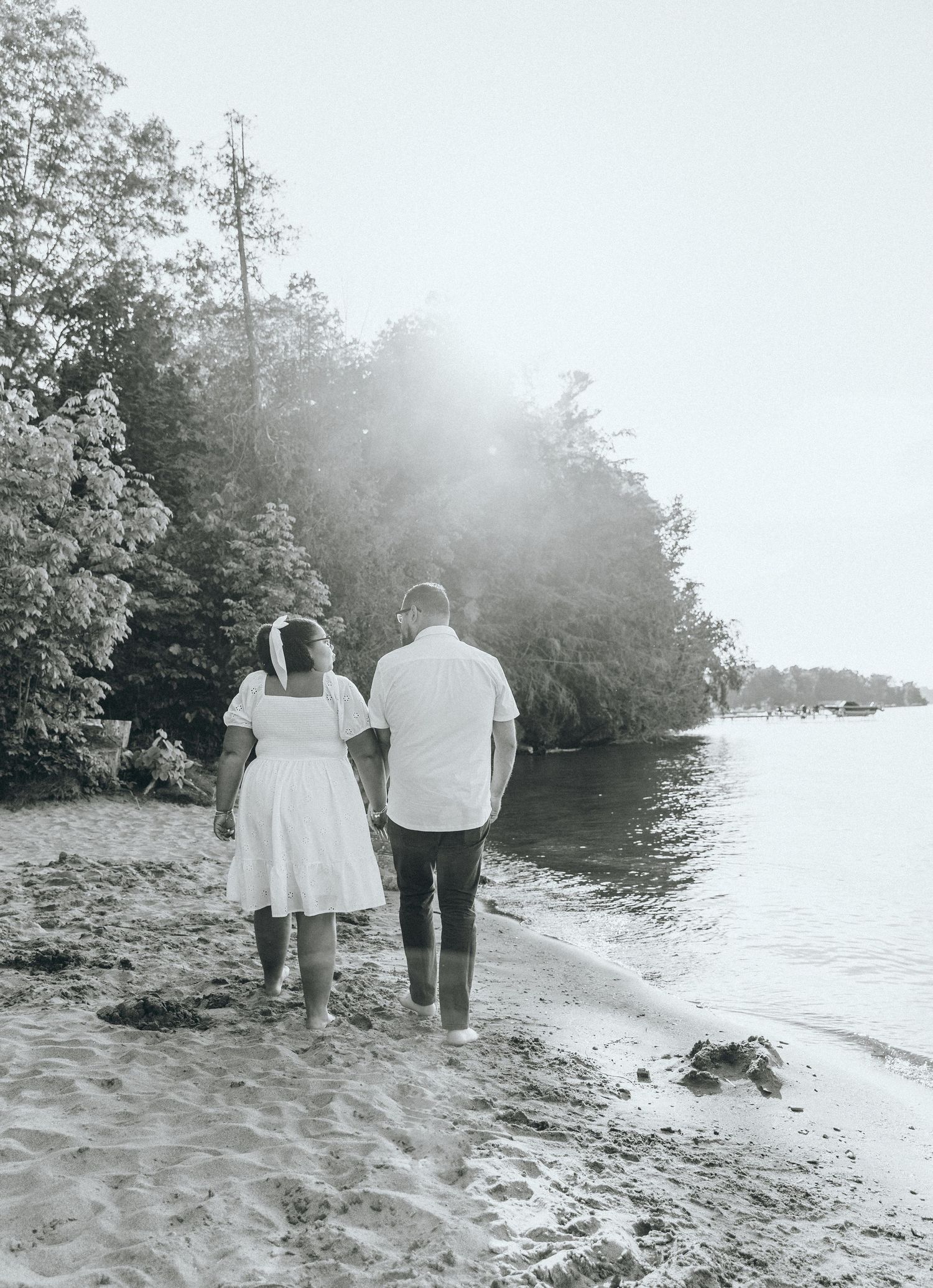 Black and white photos of a couple walking along a misty beach shoreline.