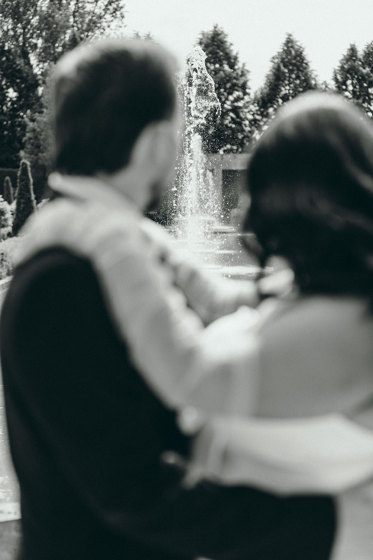 Artistic blurred black and white photo of couple embracing outdoors.