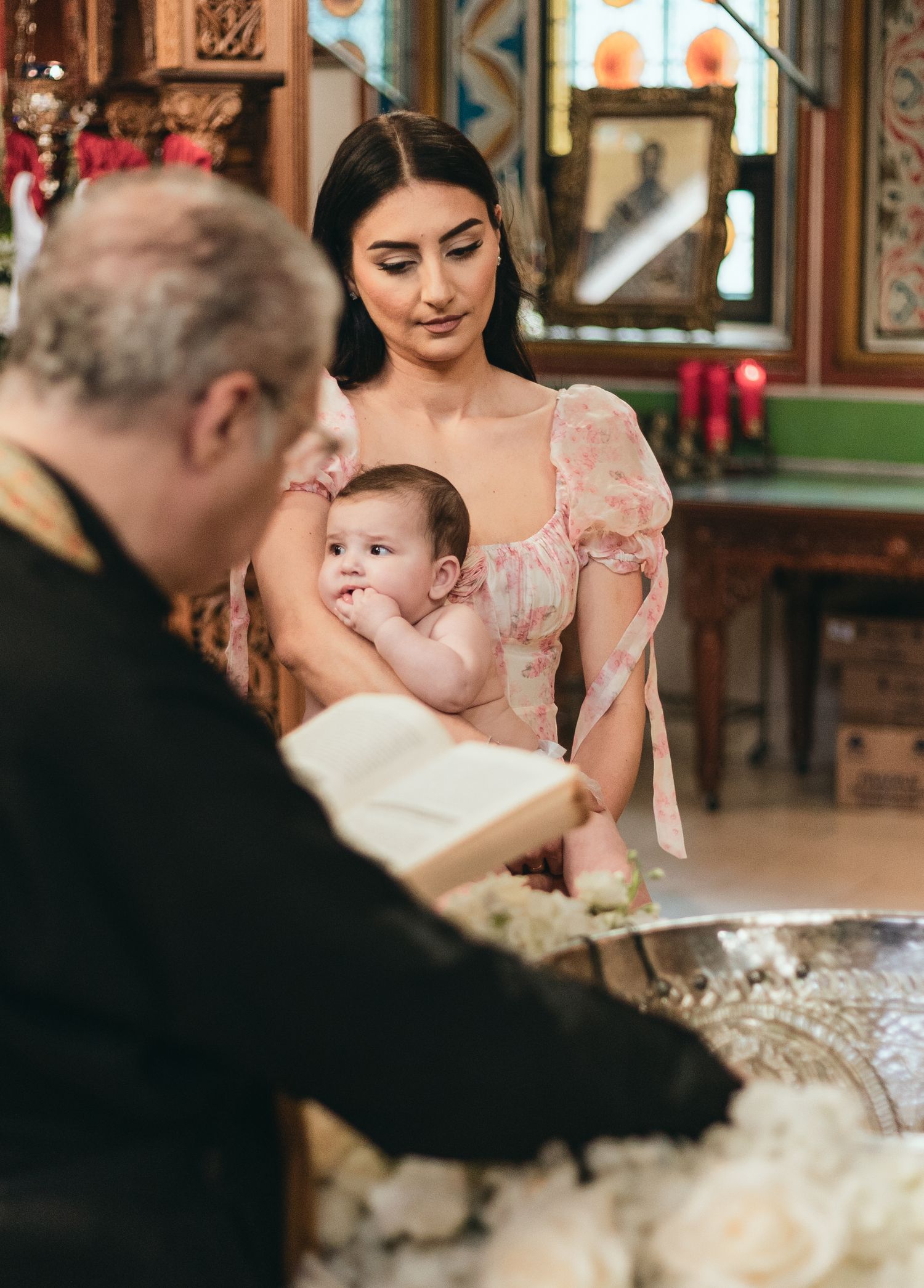 Baptism ceremony taking place in an ornately decorated church interior.