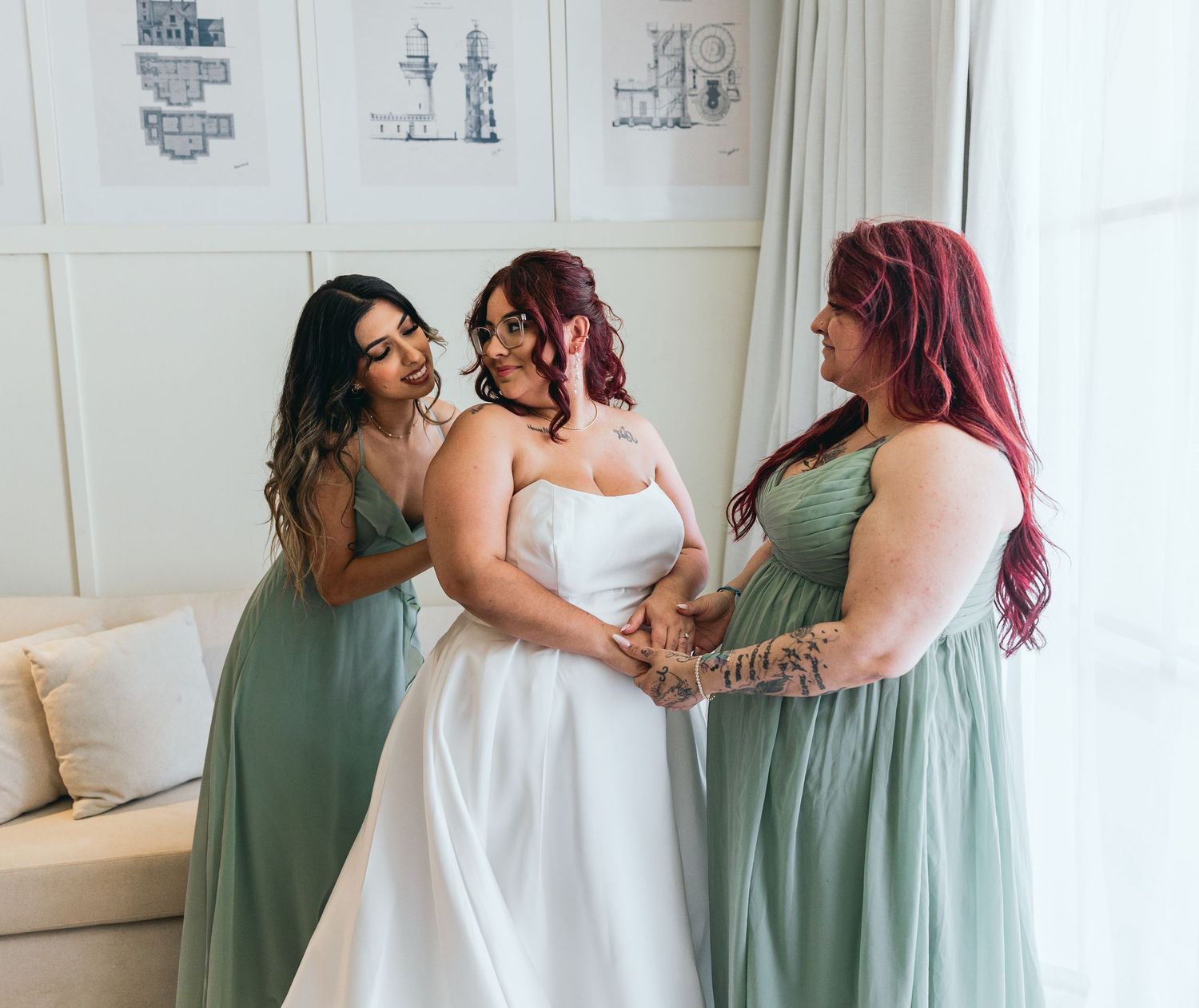 Bridesmaids in sage green dresses pose together during wedding celebrations.