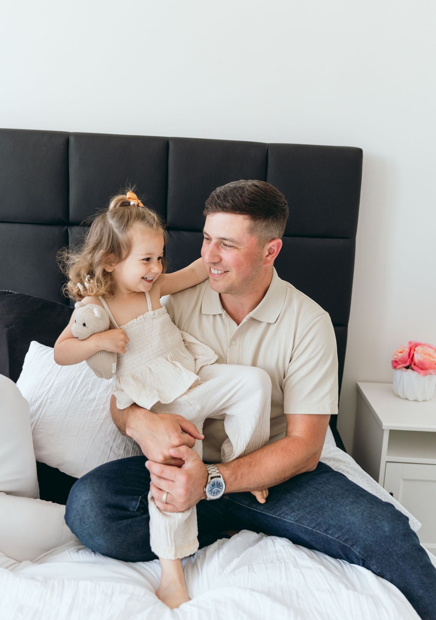 A tender family moment captured in a series of photos on a bed with white bedding.