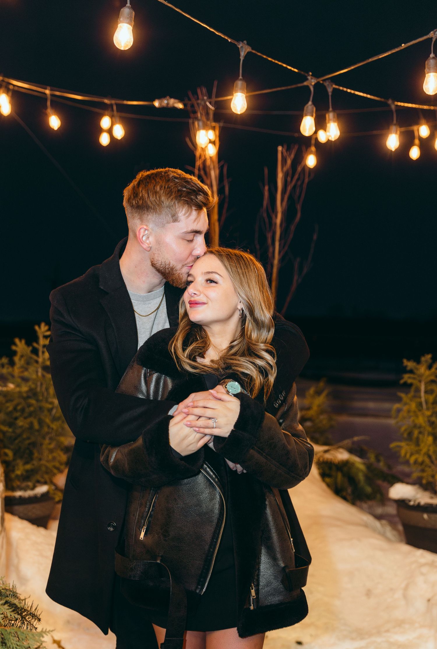Romantic evening scene under string lights with snow visible in the background.