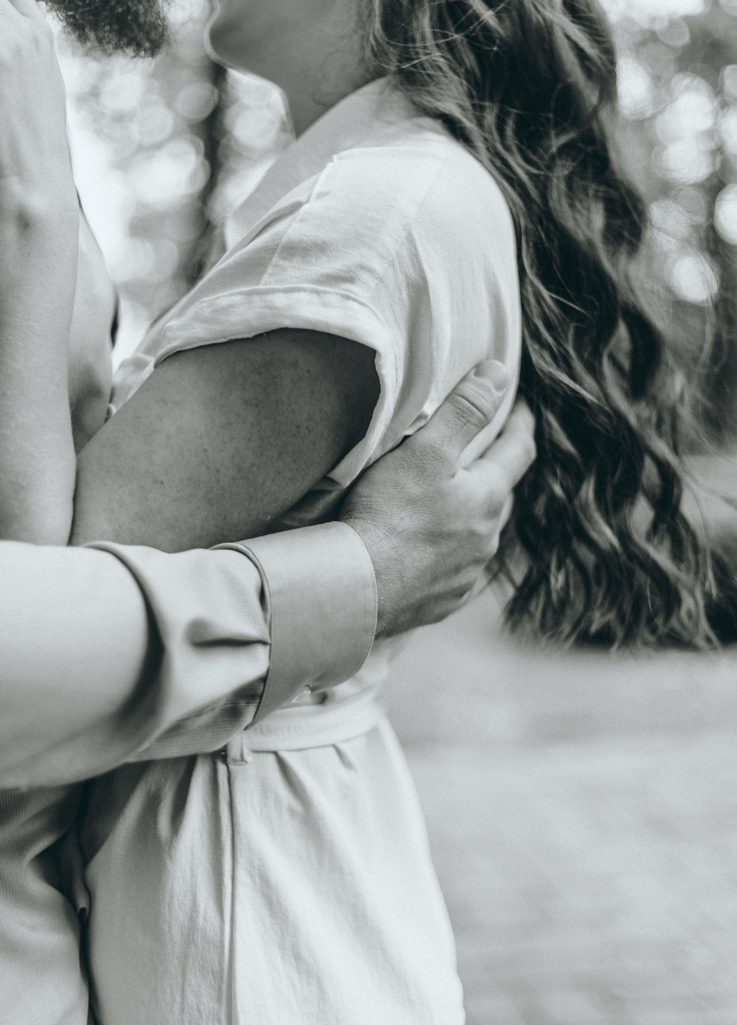 Close-up black and white photo showing tender embrace and flowing hair.