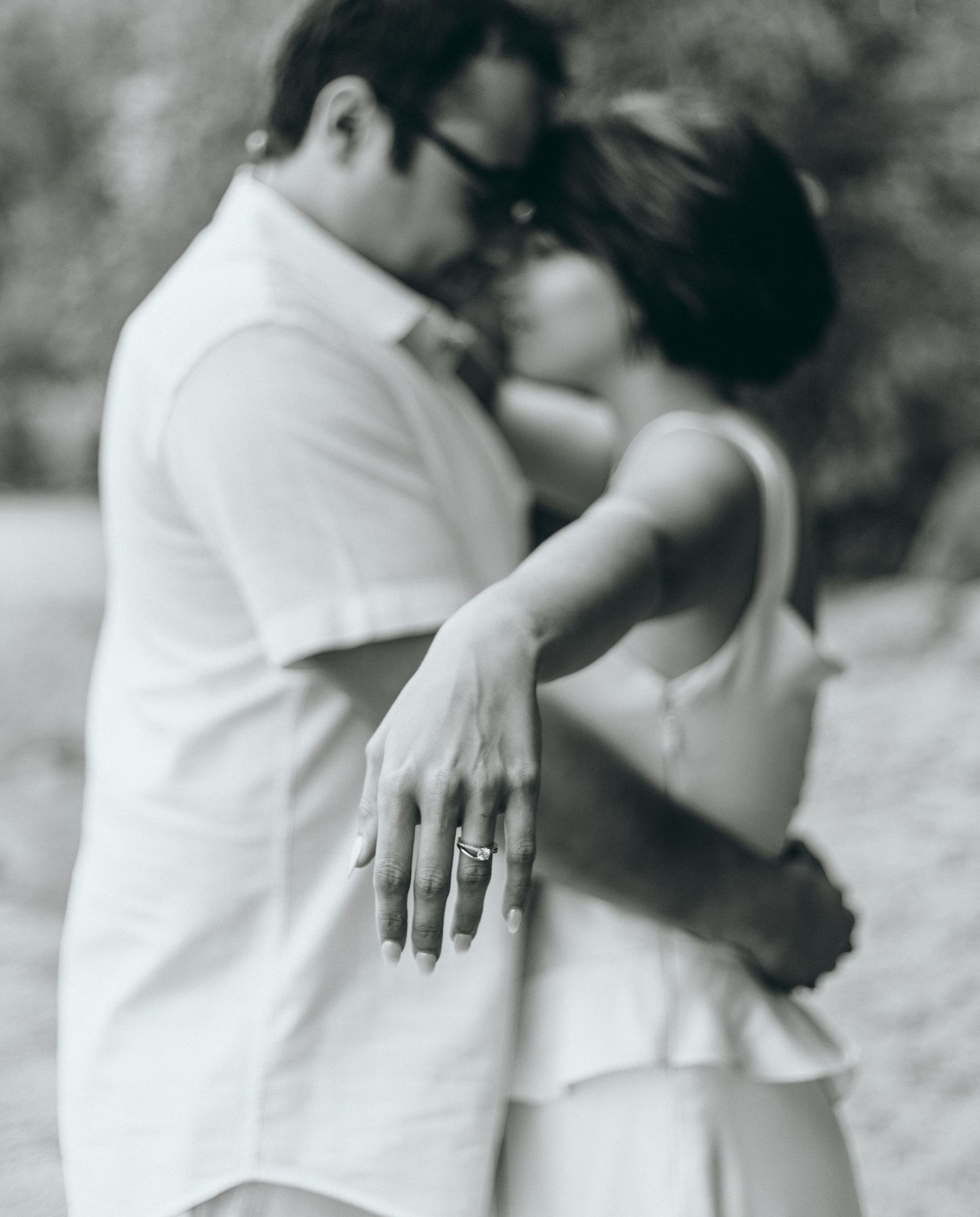 A couple in white clothing embraces in a series of romantic black and white photos.