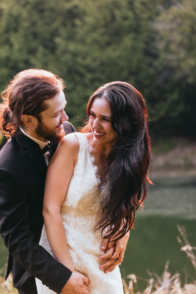 Candid wedding sequence showing joyful laughter between newlyweds by a lake.