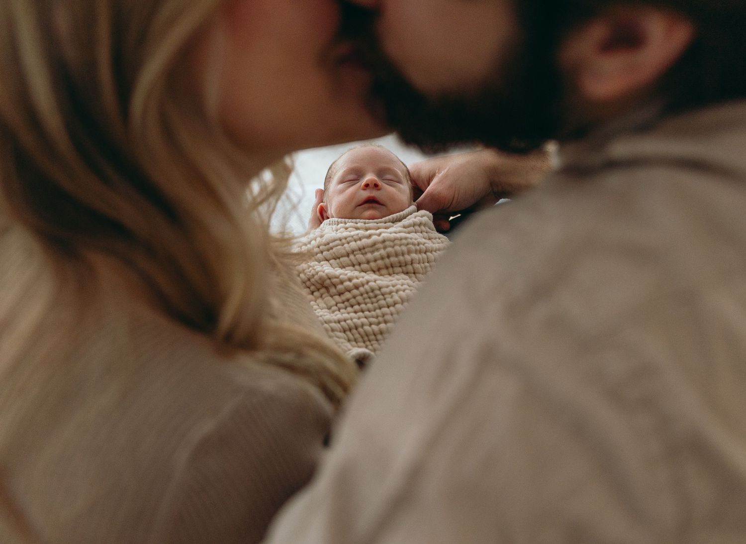 Intimate lifestyle photoshoot showing tender moments on a cozy couch with soft natural lighting.