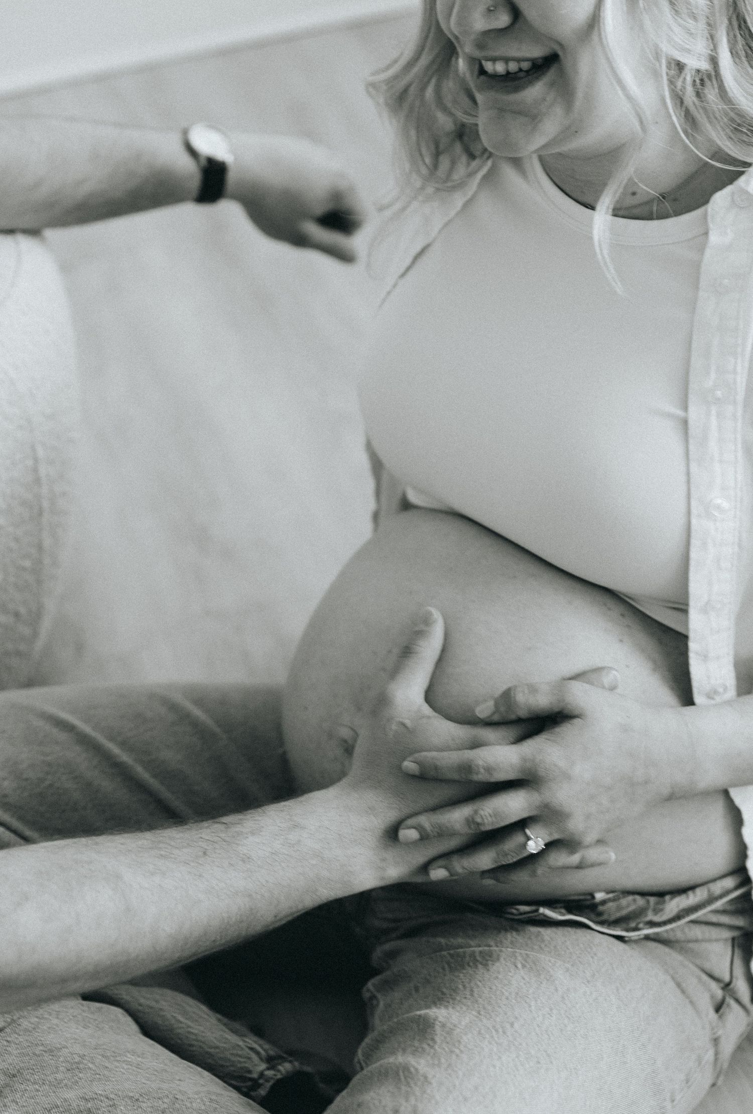 Black and white series showing a pregnancy progression with hands touching a growing baby bump.