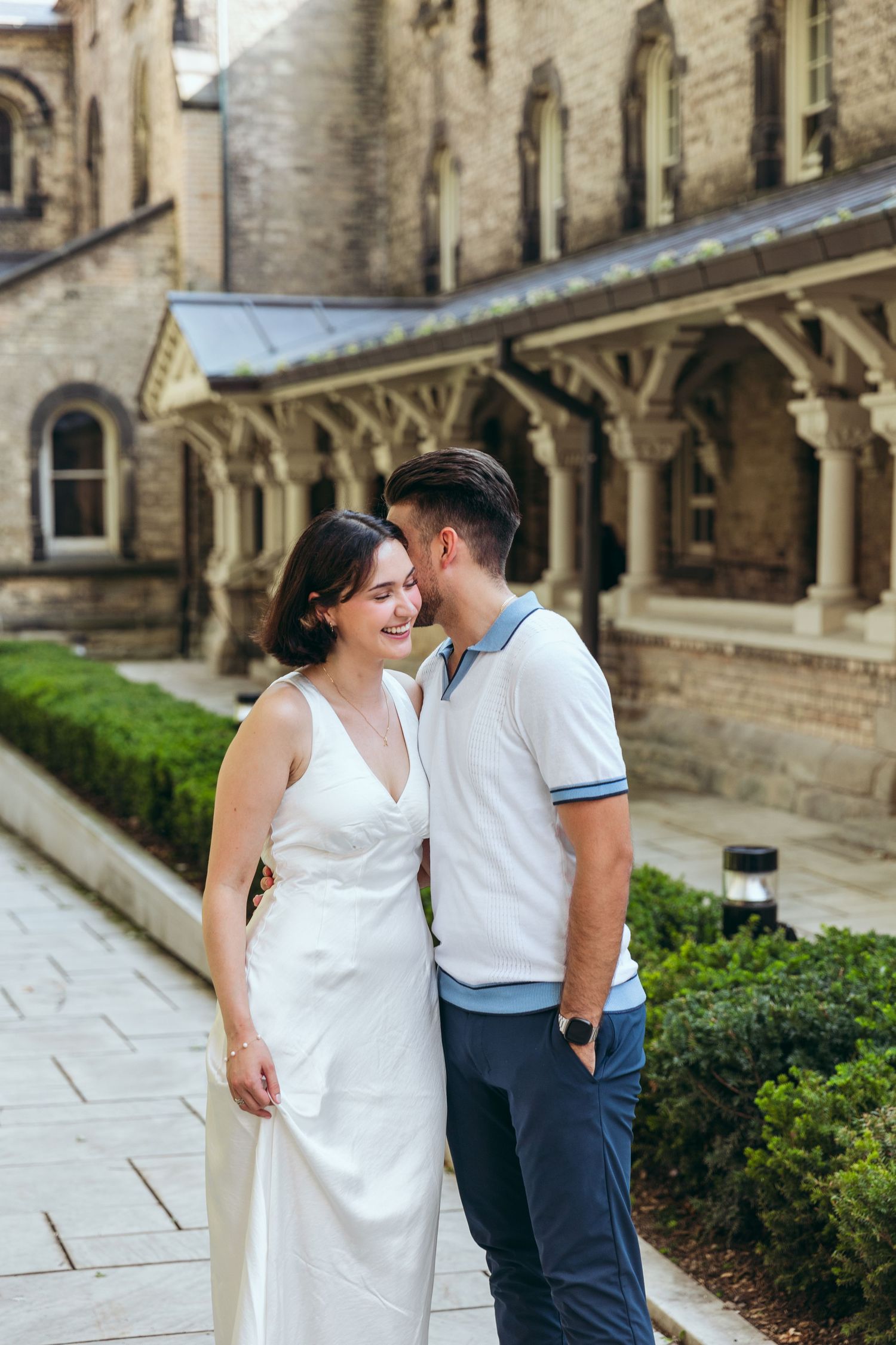 A romantic moment captured in front of ornate stone columns and Gothic architecture.