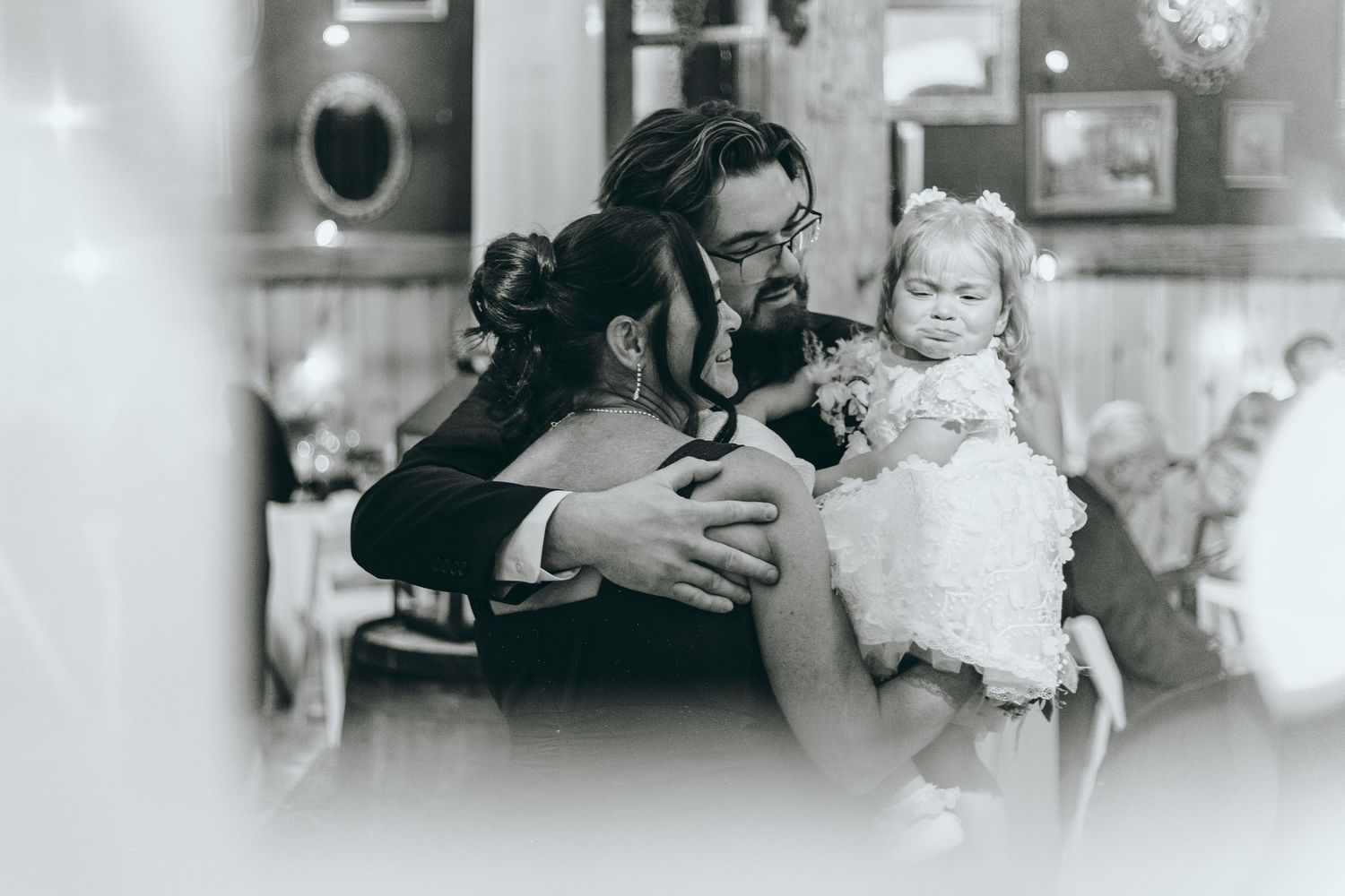 Black and white candid shots of wedding guests celebrating at a reception.
