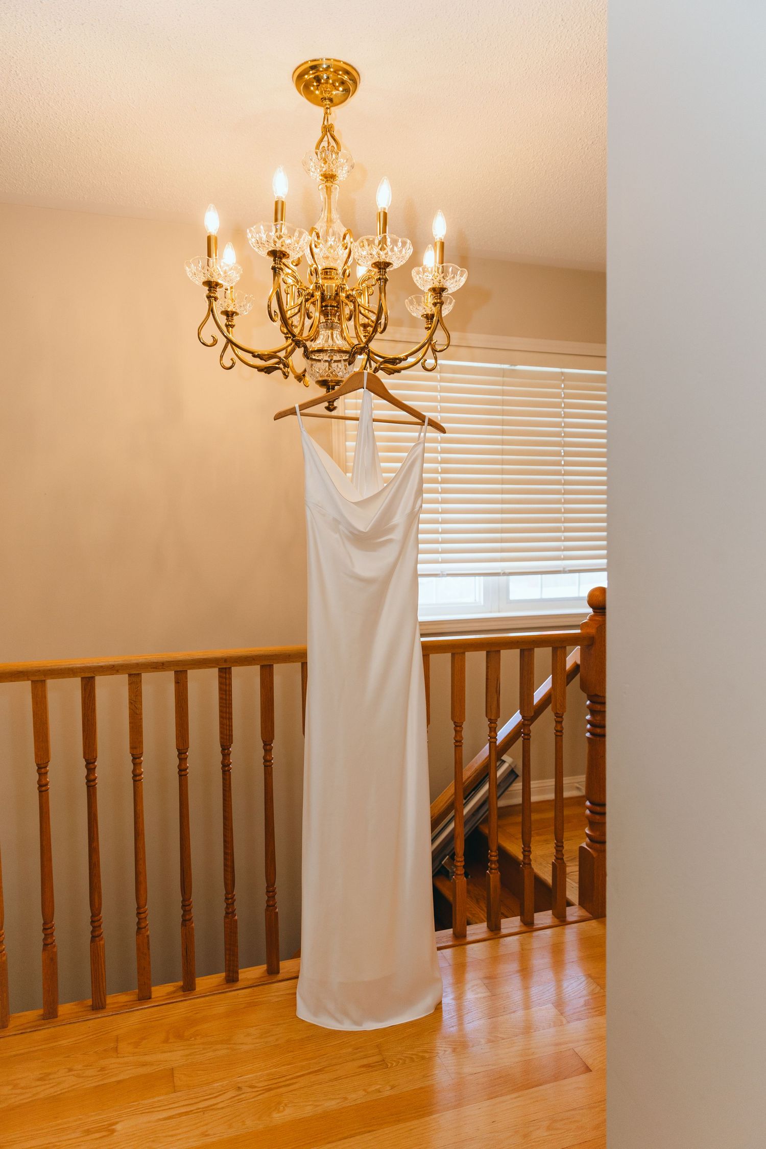 Elegant chandelier and wooden banister in a home with white fabric draping.