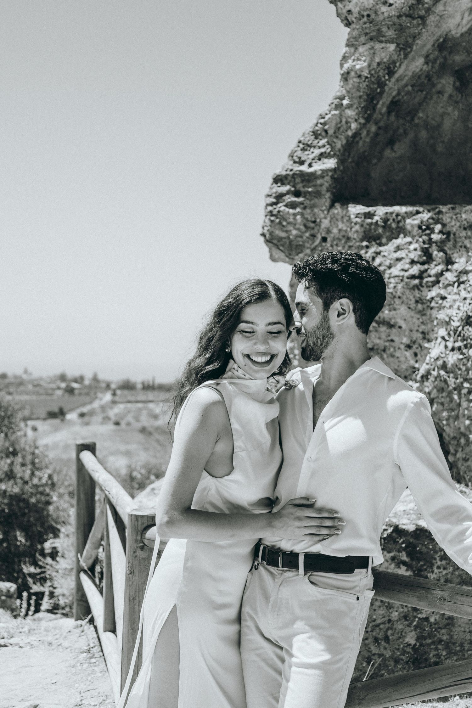 Natural light photography captures intimate moments between couple in white attire.