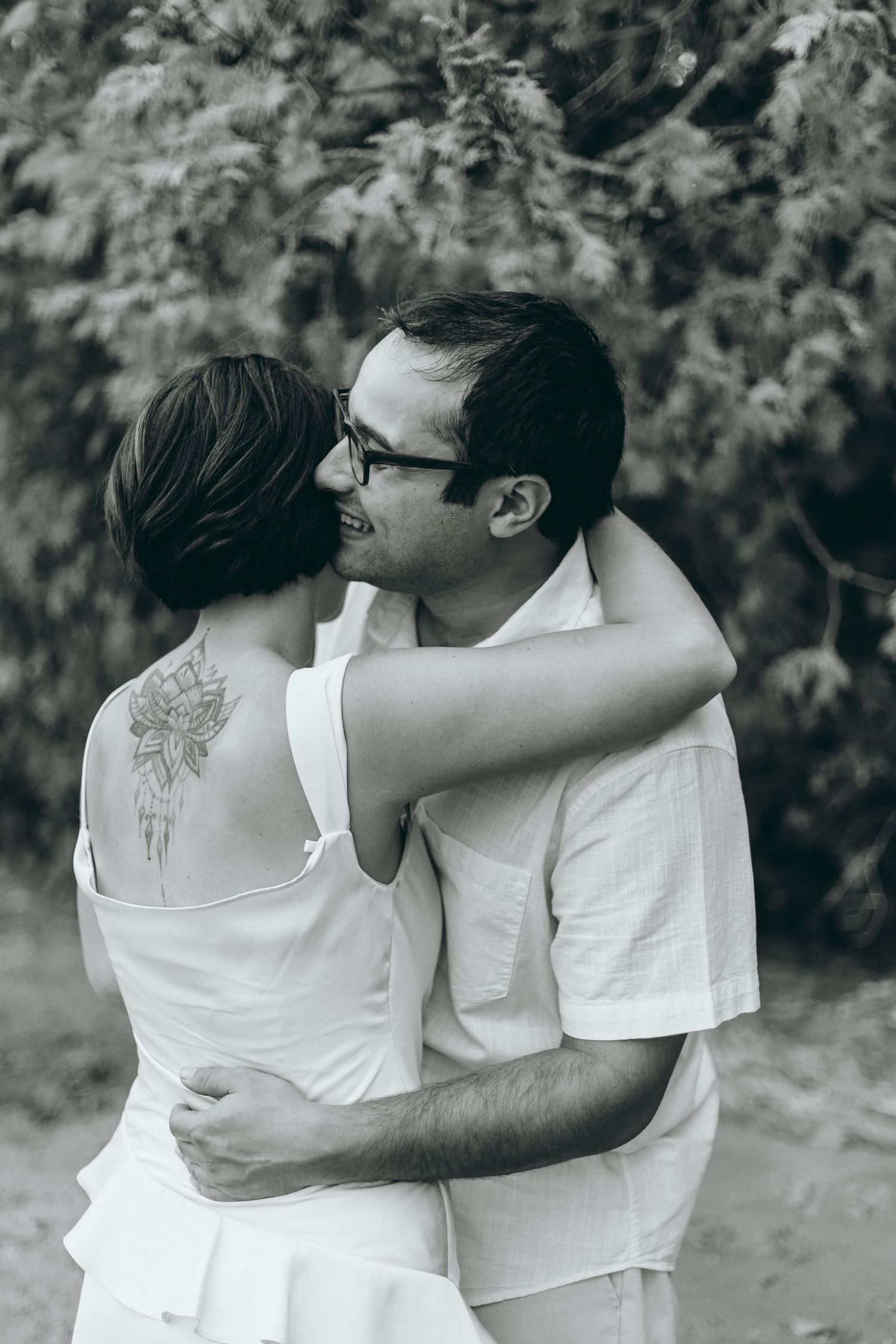 A loving embrace captured in black and white photography outdoors.