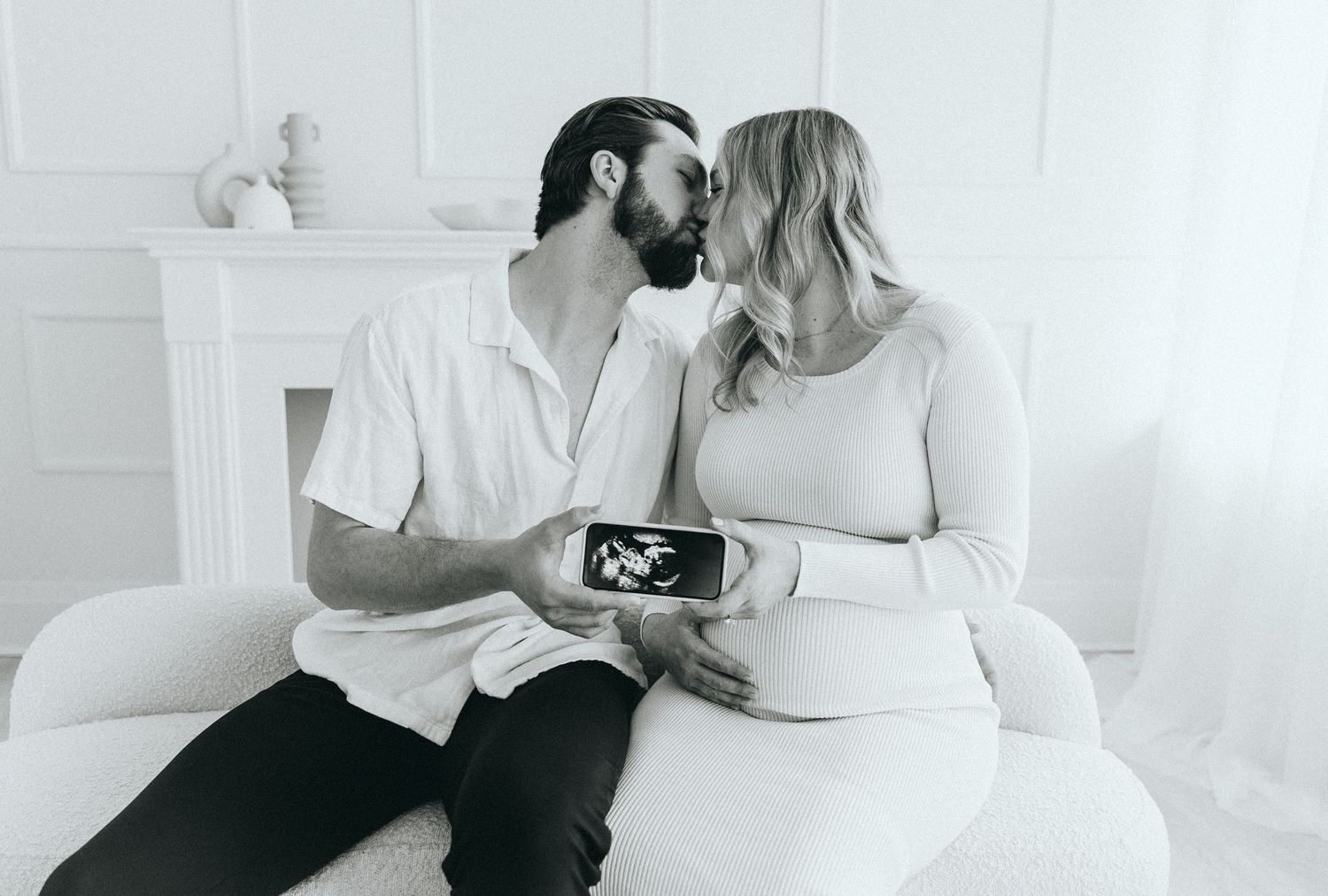 Expecting couple sharing ultrasound photo while sitting together.