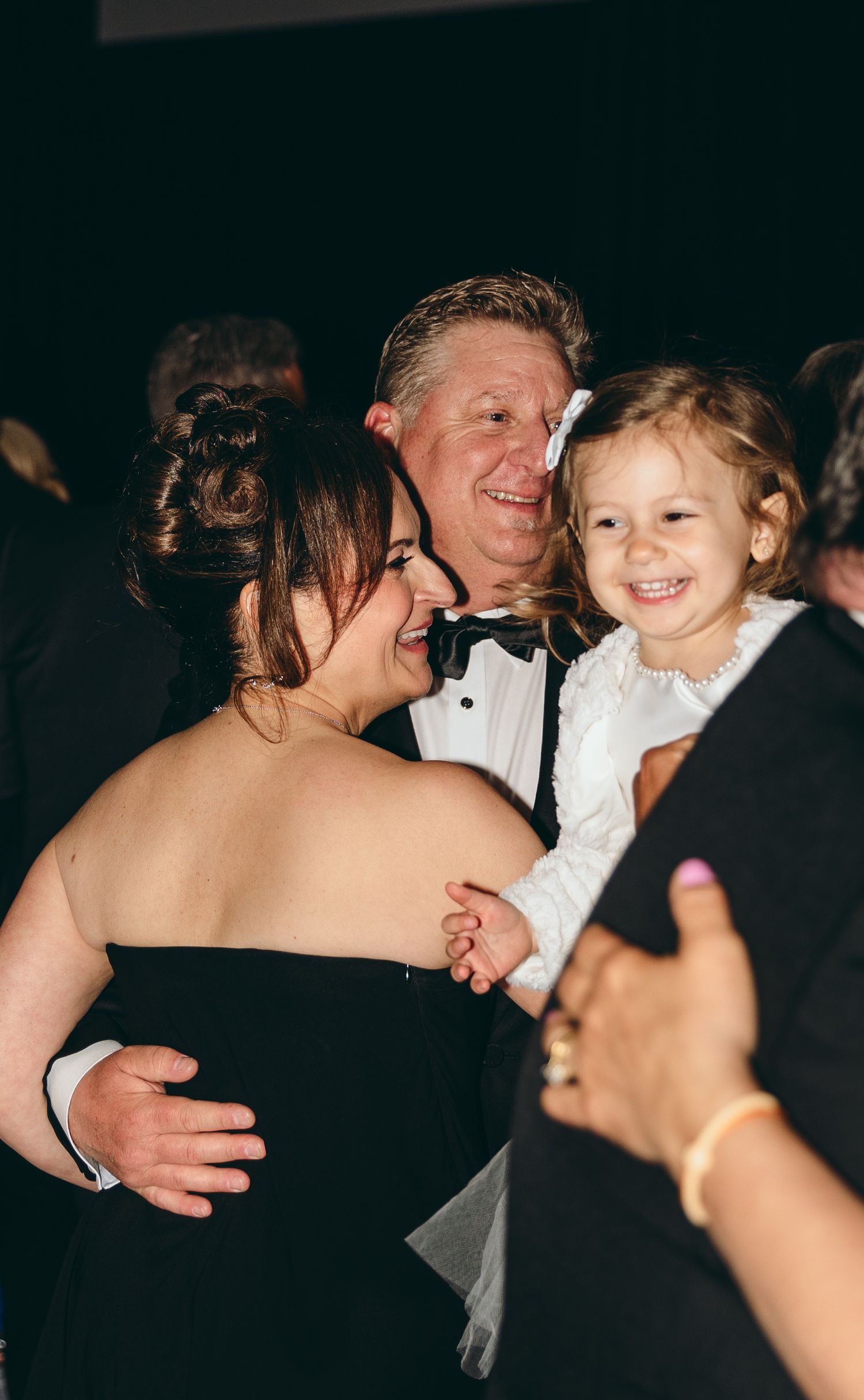 Candid moment of guests dancing and laughing at formal event.