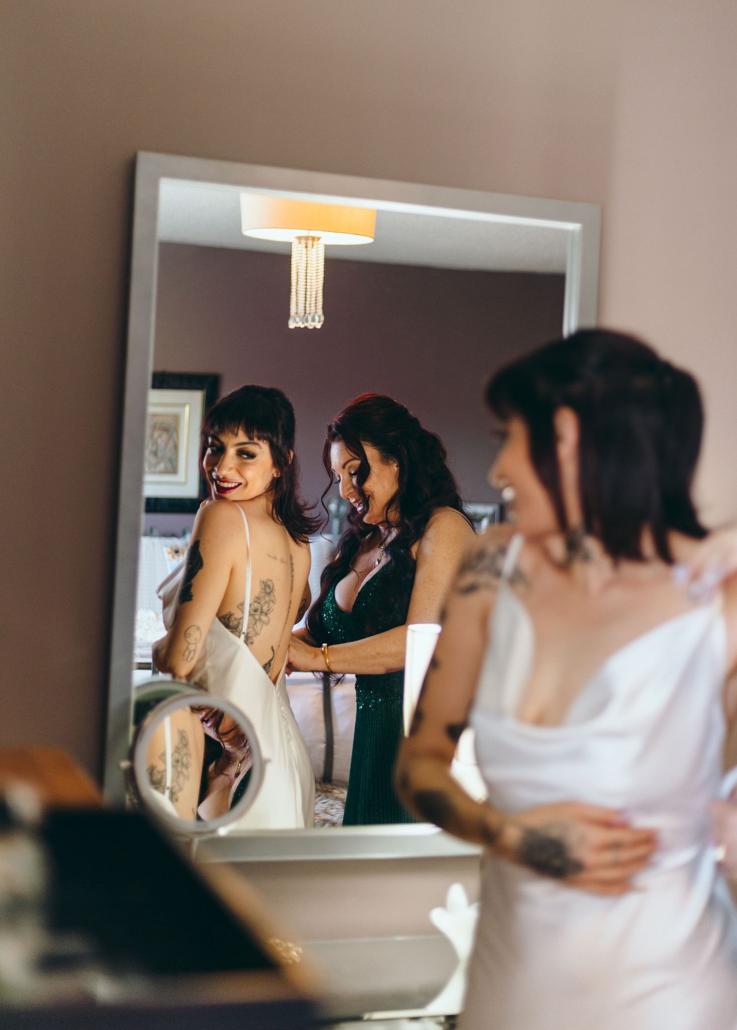 People getting ready in a bathroom with warm lighting and mirrors.