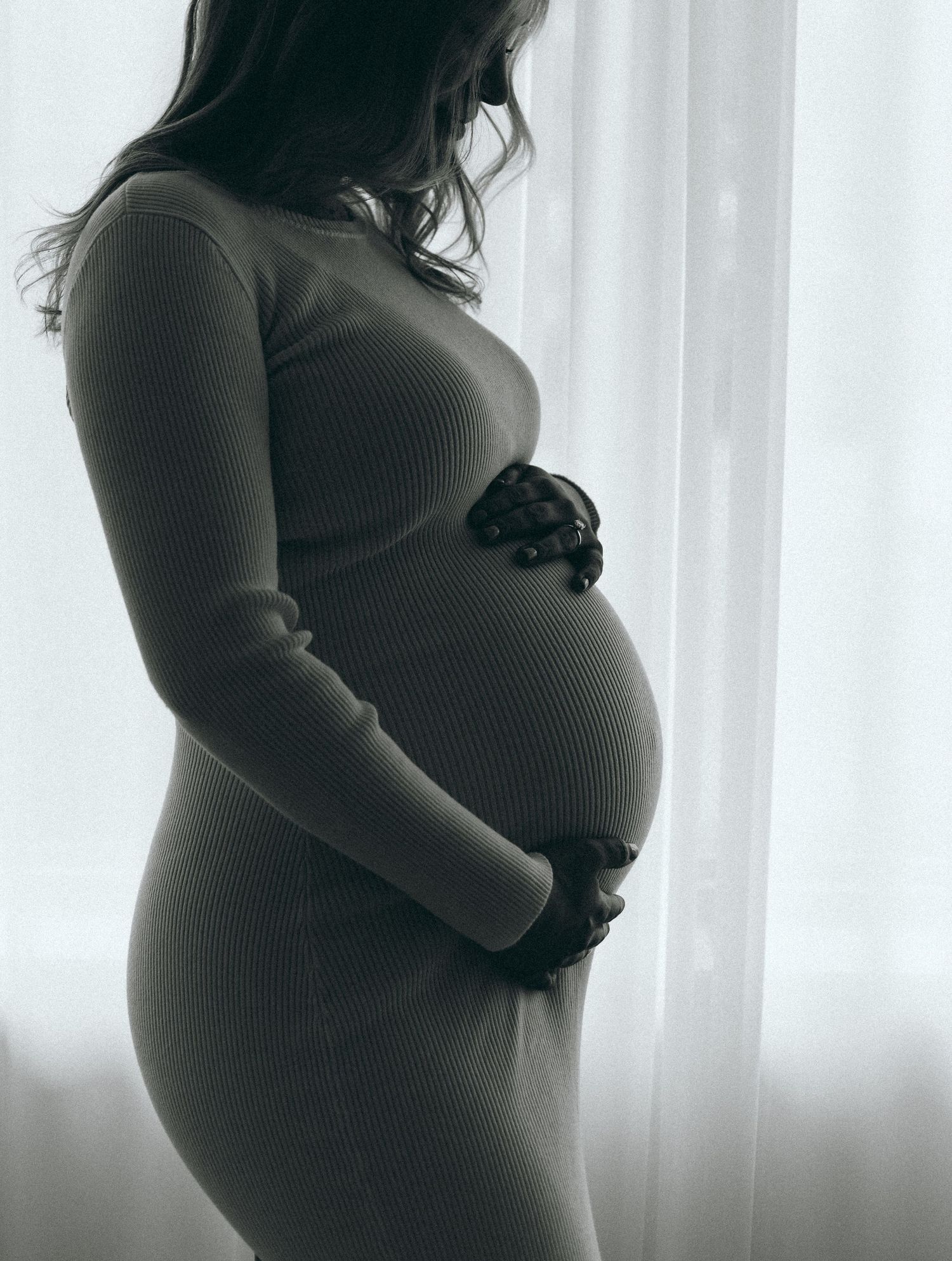 Silhouette profile shots showing progression of pregnancy against window light.