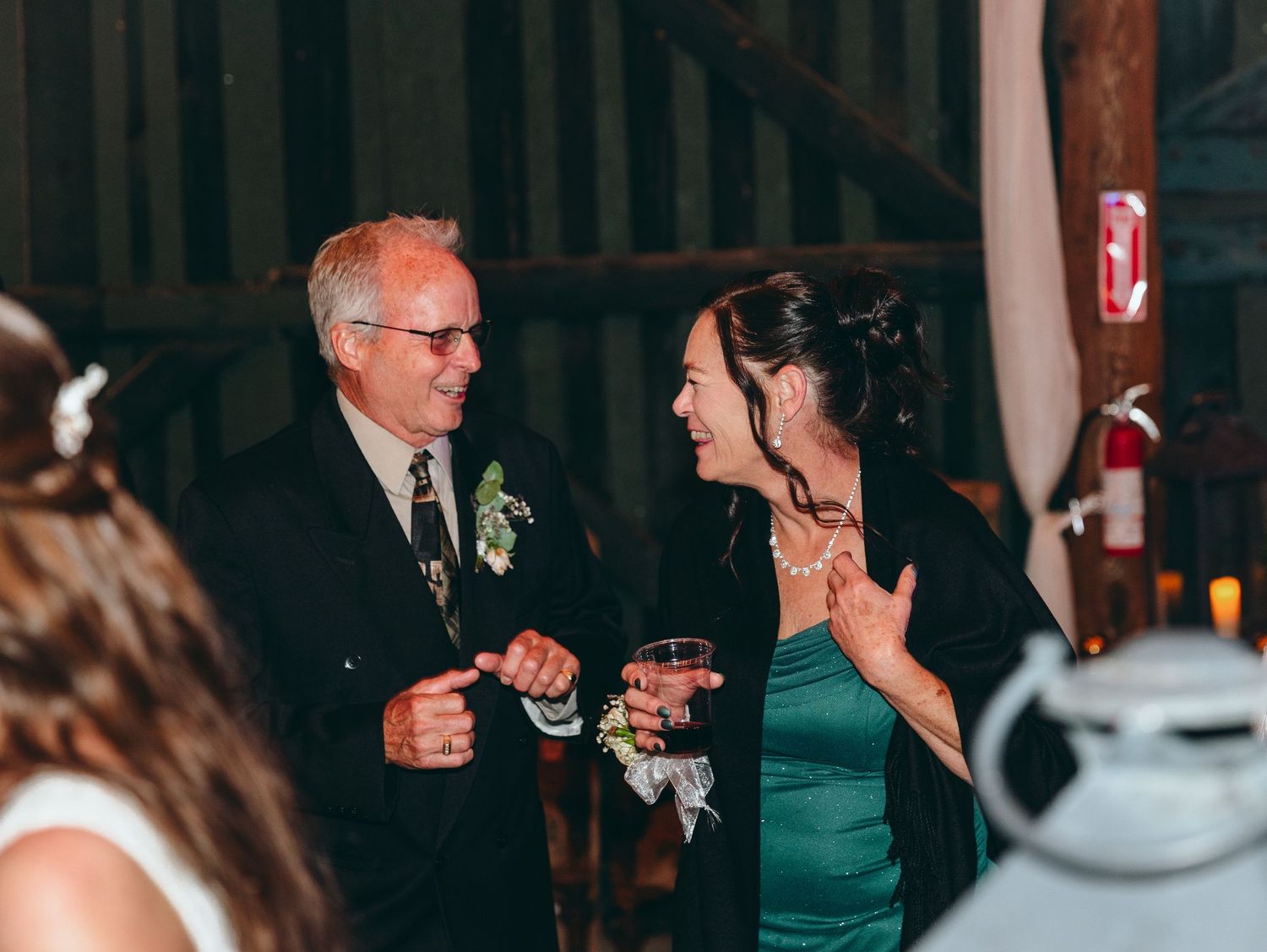 Wedding reception guests mingling and dancing under warm indoor lighting.