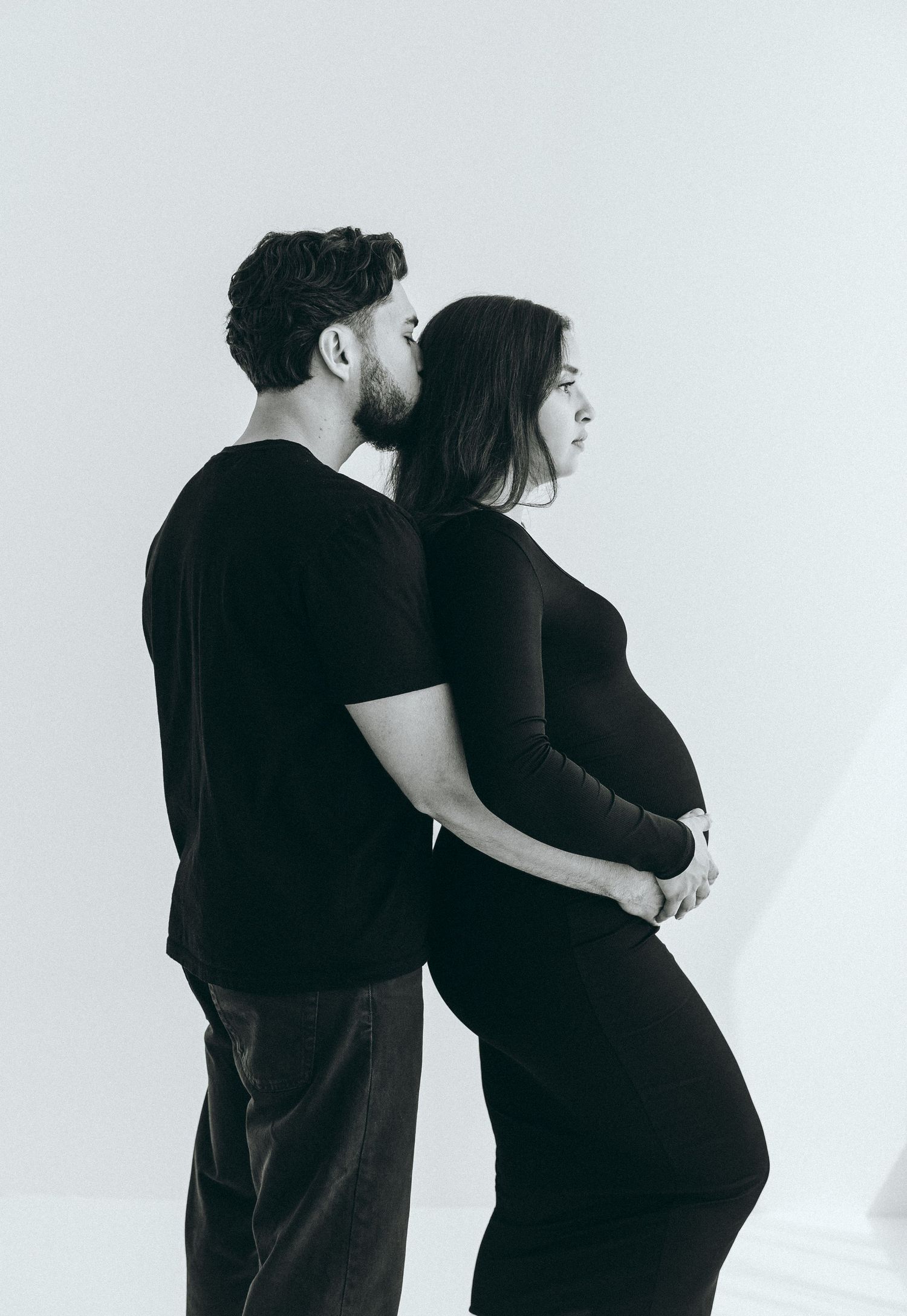 Intimate black and white maternity photos showing couple's silhouettes.