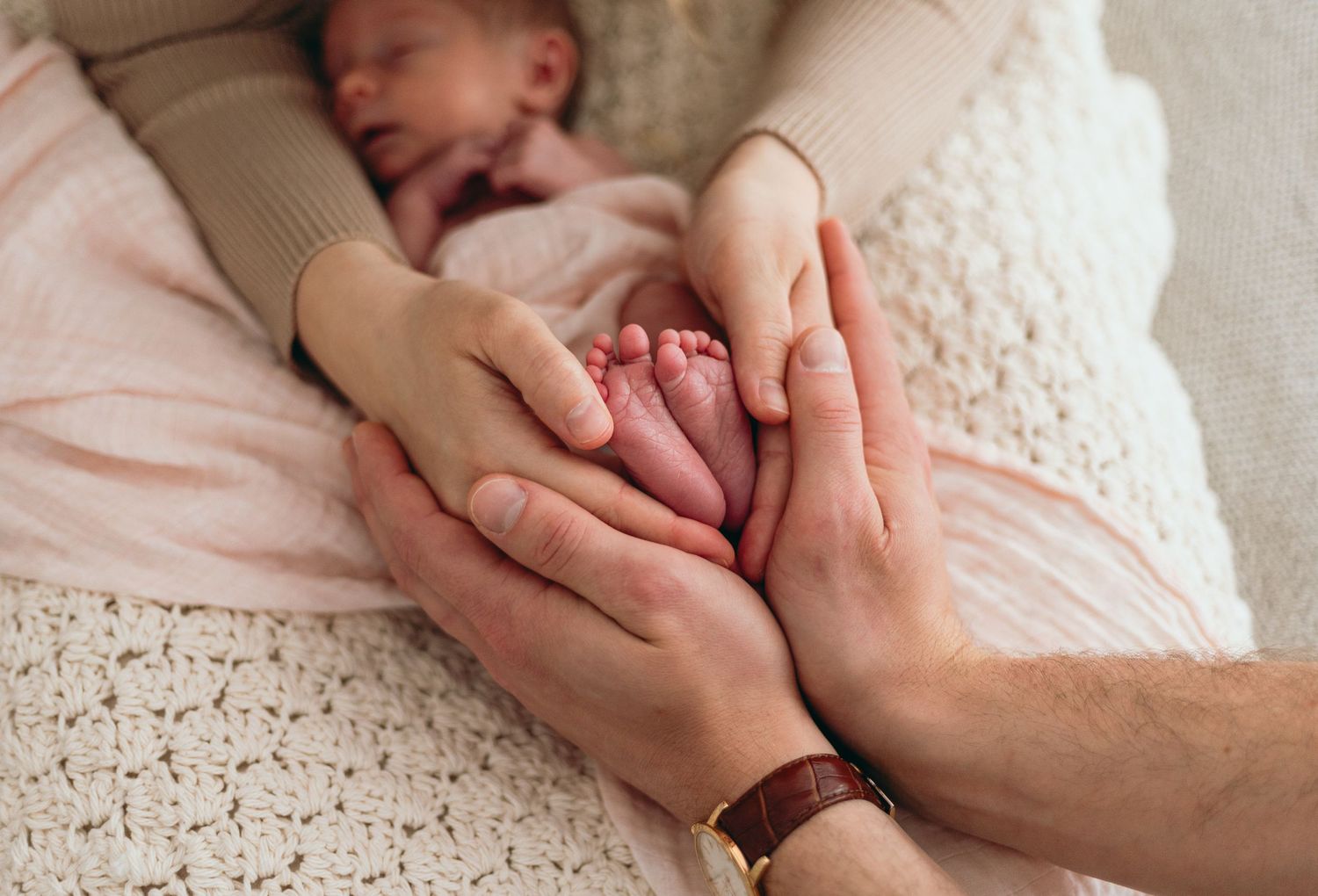 Close-up of hands touching on textured surface in soft lighting.