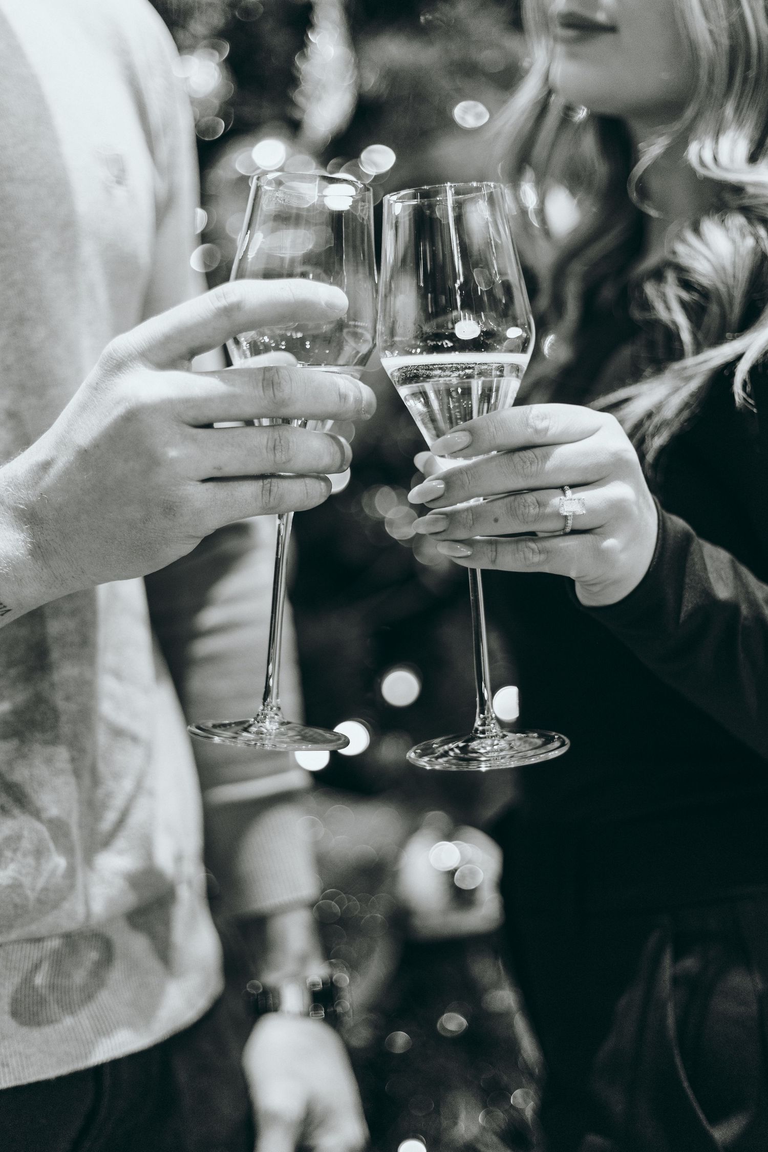 Two hands holding wine glasses together in a celebratory toast.