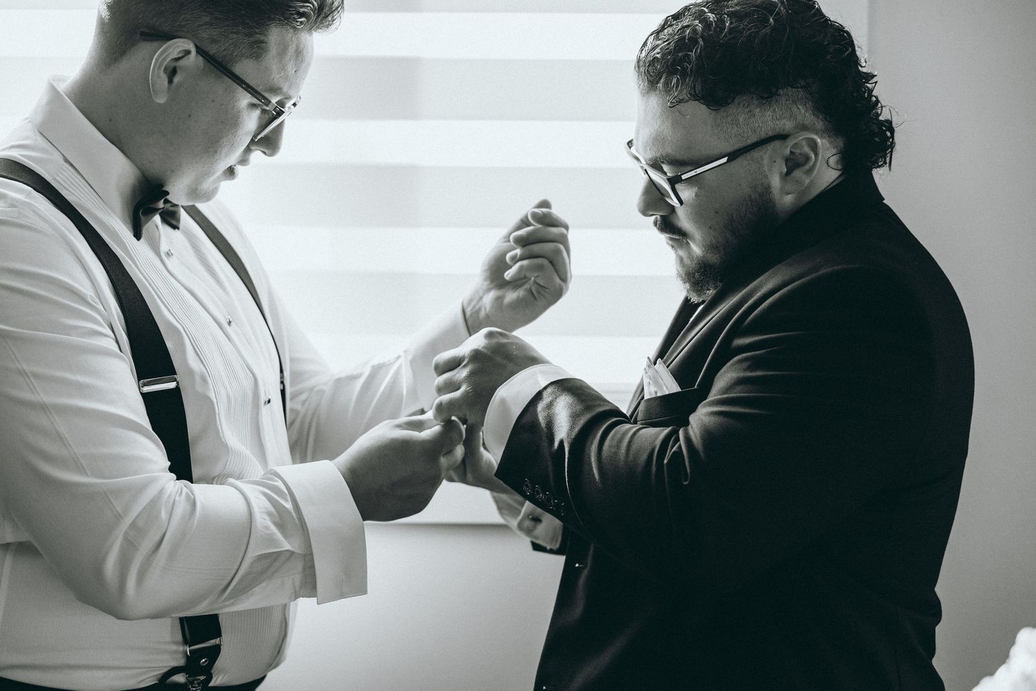Wedding preparation scene with two people in formal attire interacting.