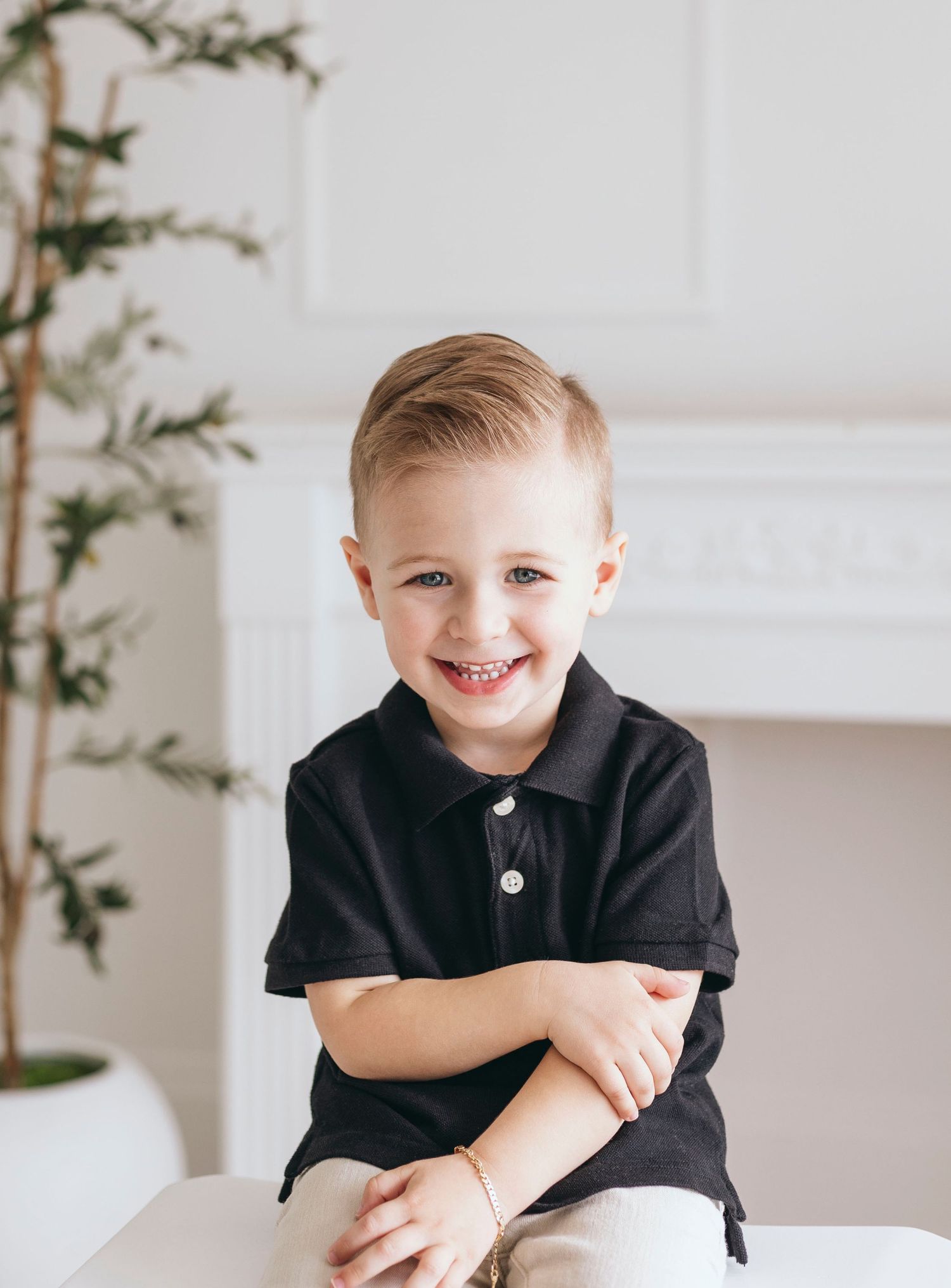 Bright and airy studio portraits in a minimalist white room with green plant decor.