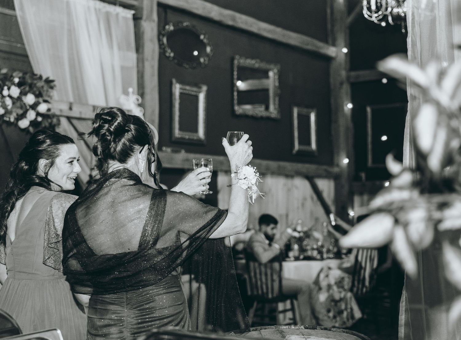 Wedding reception guests dancing and celebrating together in a rustic barn venue.