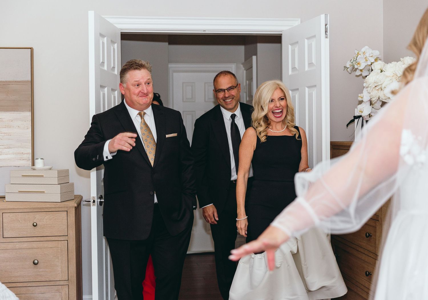 Candid wedding moments captured in hallway with natural light.