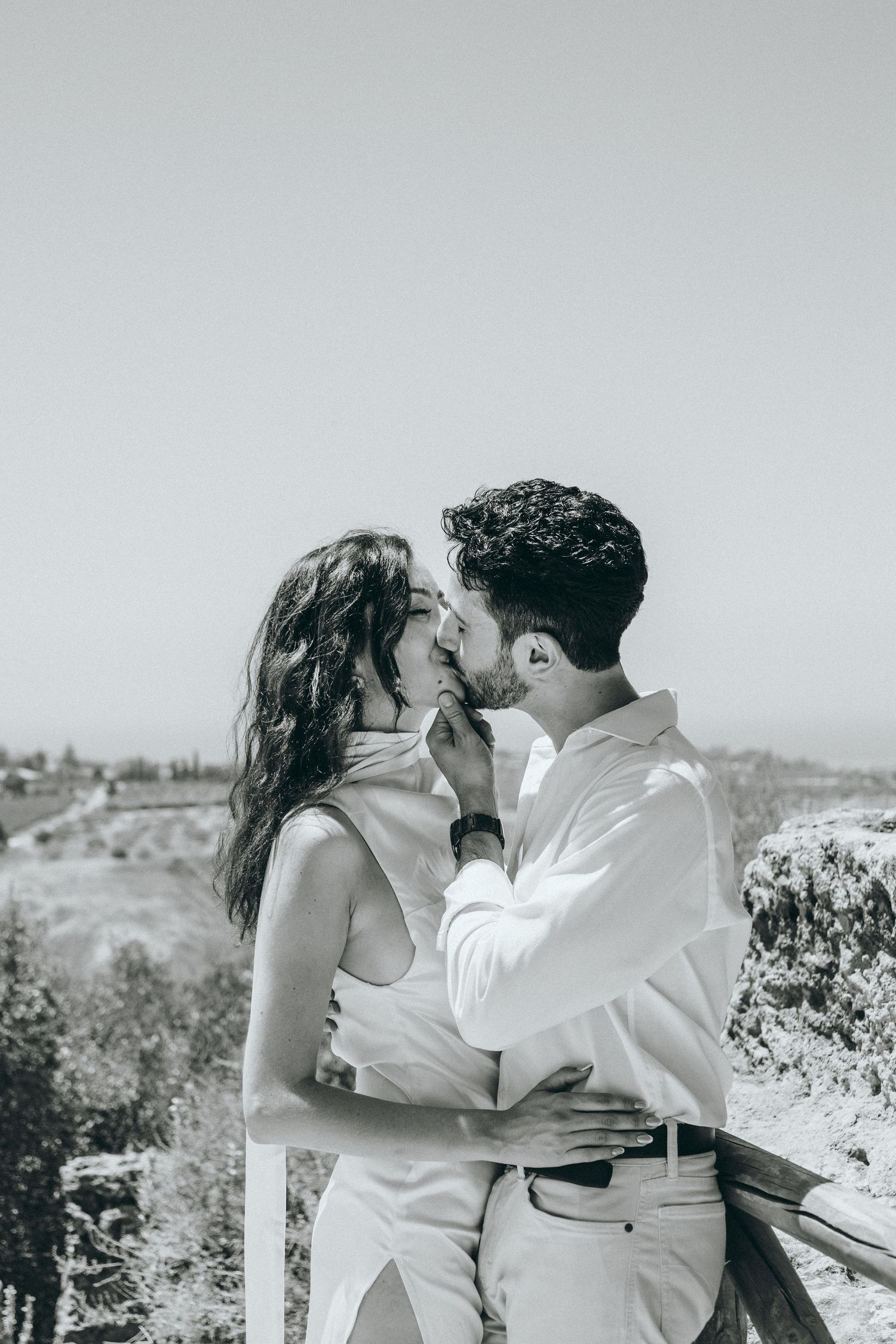 Romantic moment captured in black and white against a natural outdoor backdrop.