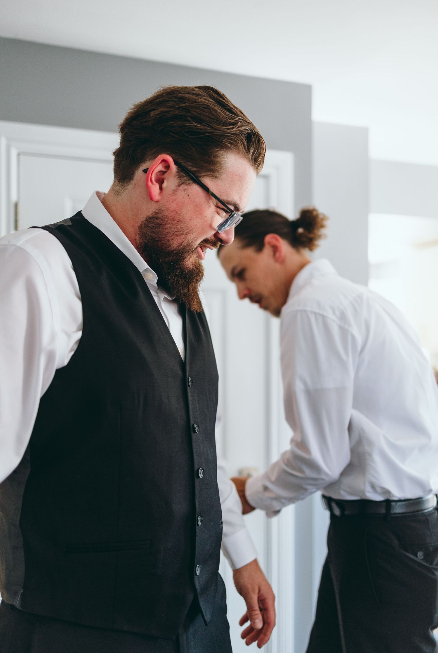Groomsmen getting ready in formal attire before wedding ceremony.