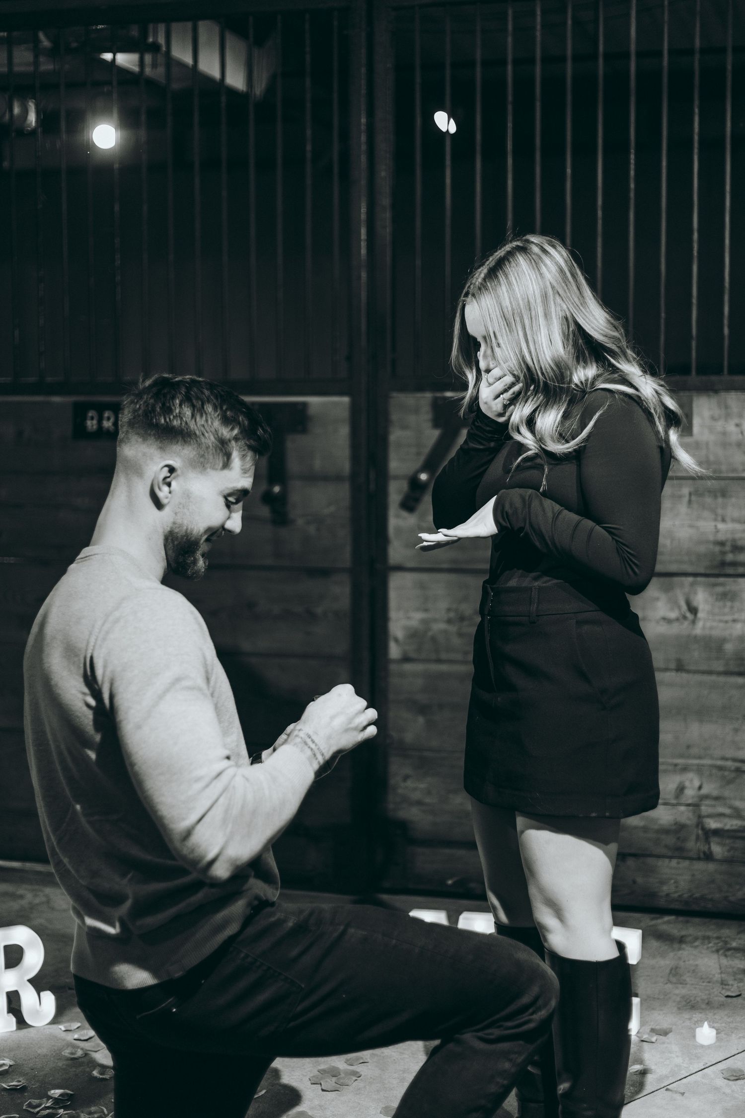 Couple sharing intimate moment in rustic indoor setting with wooden walls.
